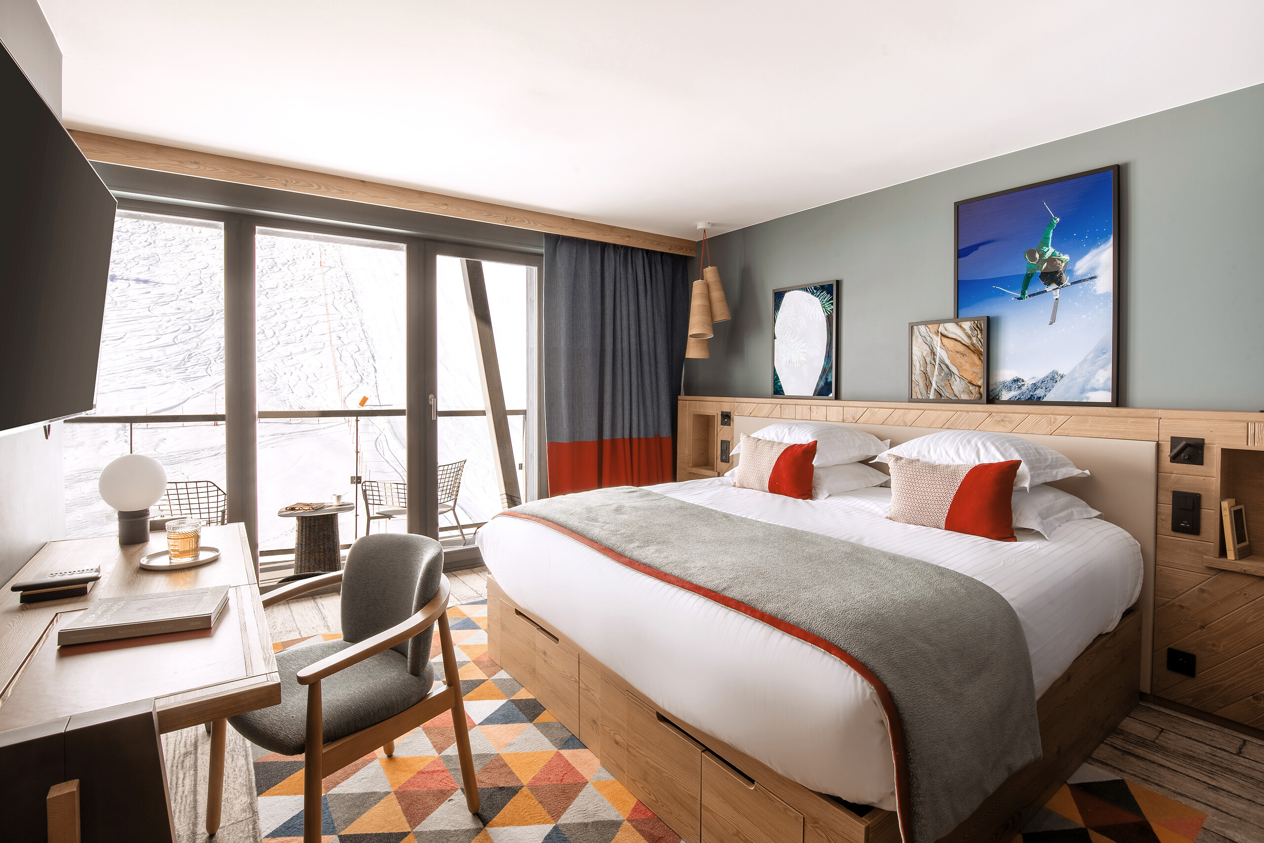 Exclusive Collection family suite bedroom with a king-size bed, seating and balcony windows at Club Med Tignes