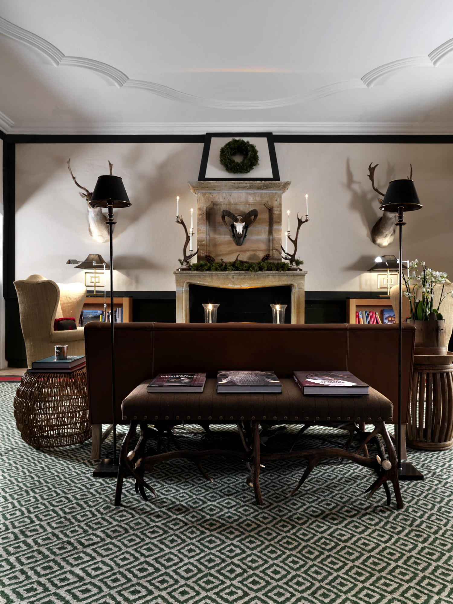 Hotel lounge with leather seating, fireplace and antler decor at House of Hütter – Wachtelhof, Hinterthal, Austria