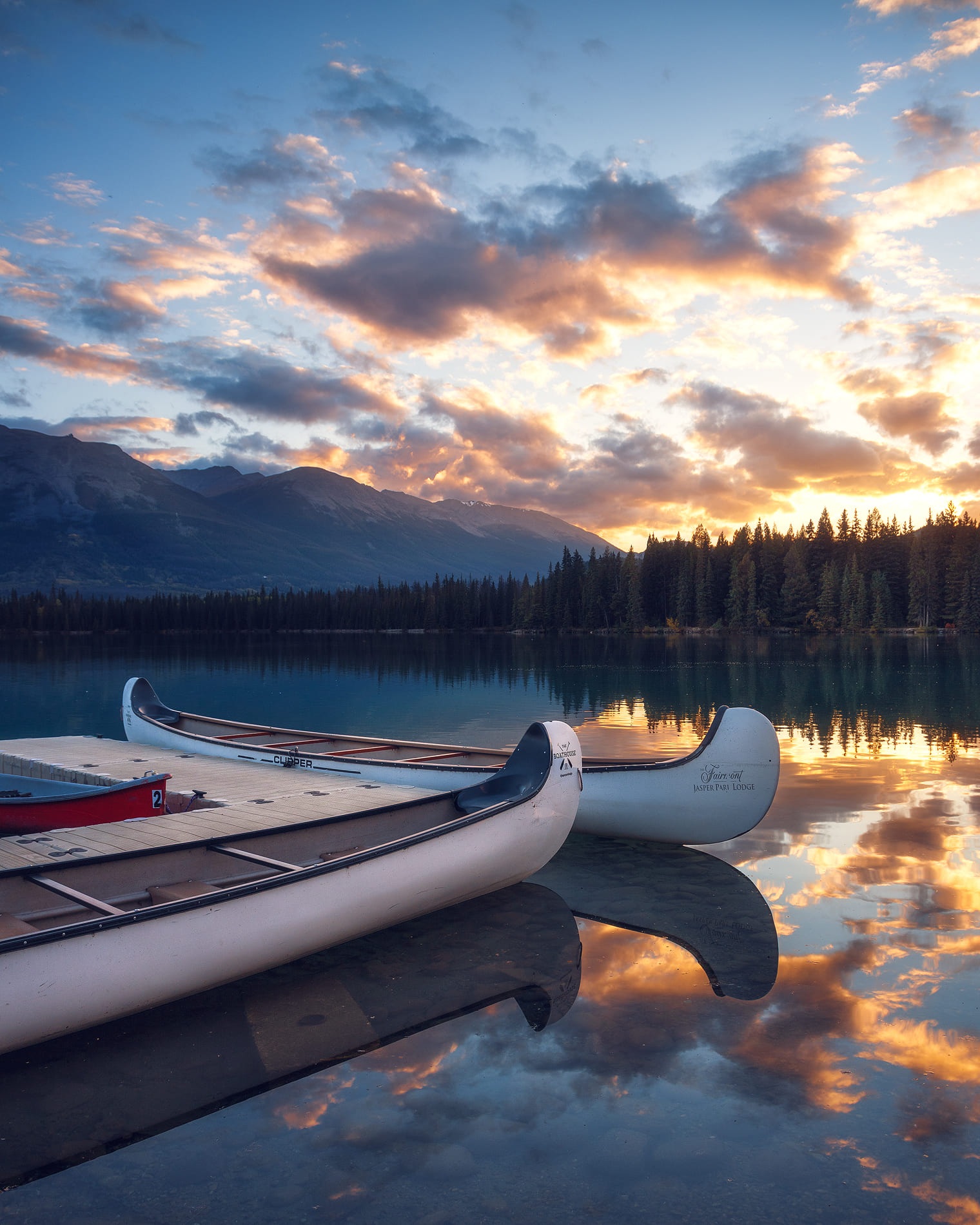 Canoes along the lakeshore at sunset at Fairmont Jasper Park Lodge, Jasper, Canada