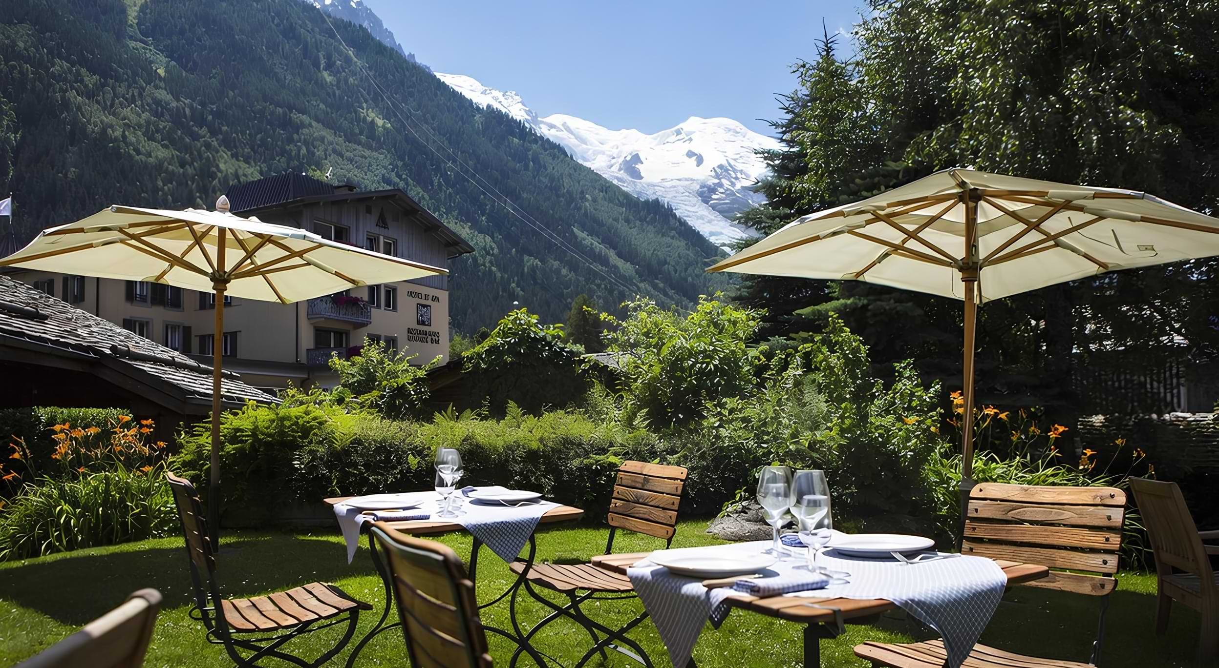 La Maison Carrier garden terrace with parasols and views towards the Mont Blanc massif, Le Hameau Albert 1er, Chamonix, France