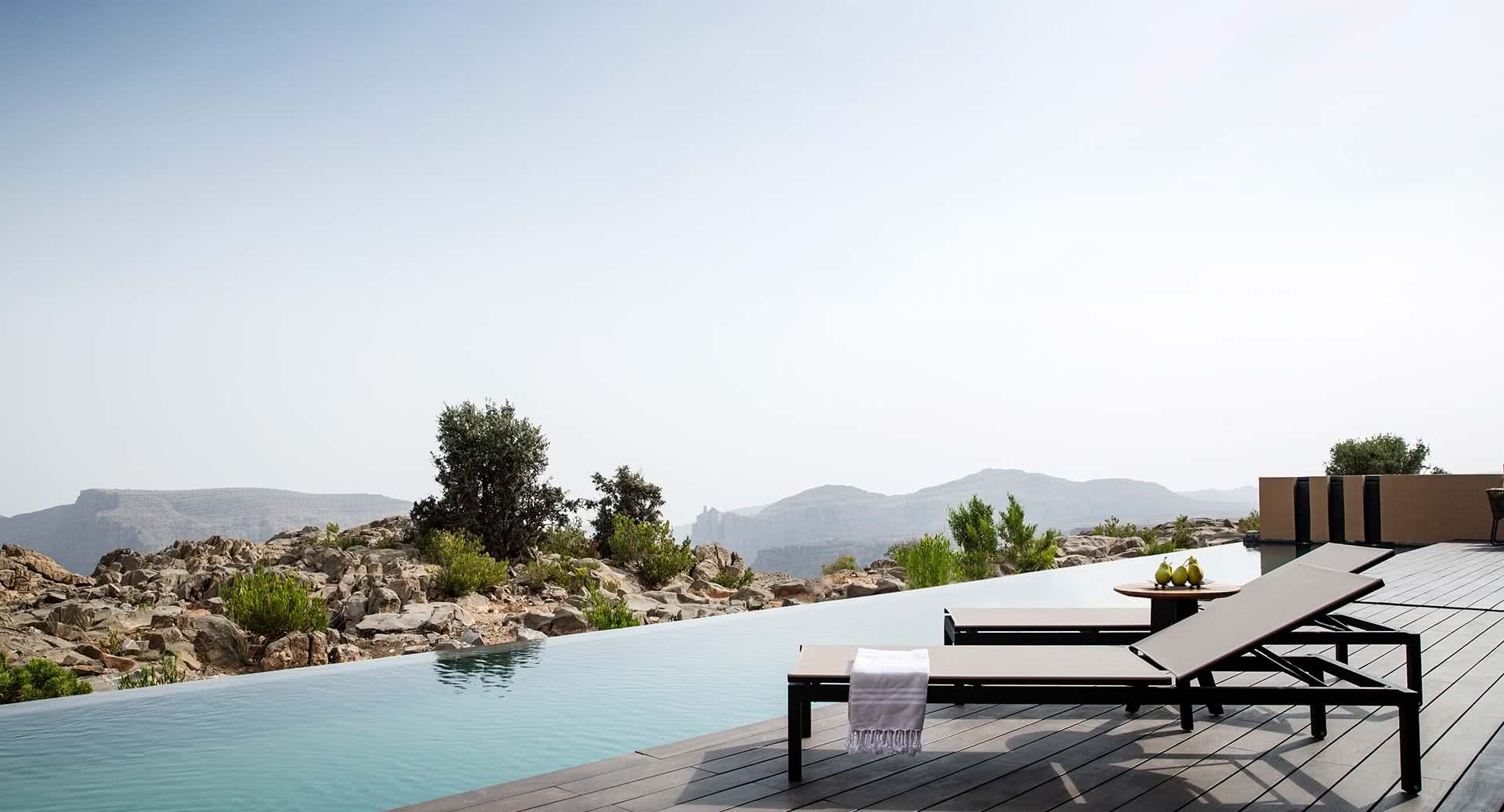 Infinity pool and loungers overlooking rocky mountain terrain, Anantara Al Jabal Al Akhdar, Jebel Akhdar, Oman