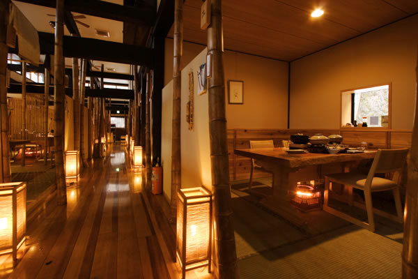 Warmly lit Chikutei dining space with low tables and wooden partitions at Takaragawa Onsen Osenkaku, Gunma, Japan