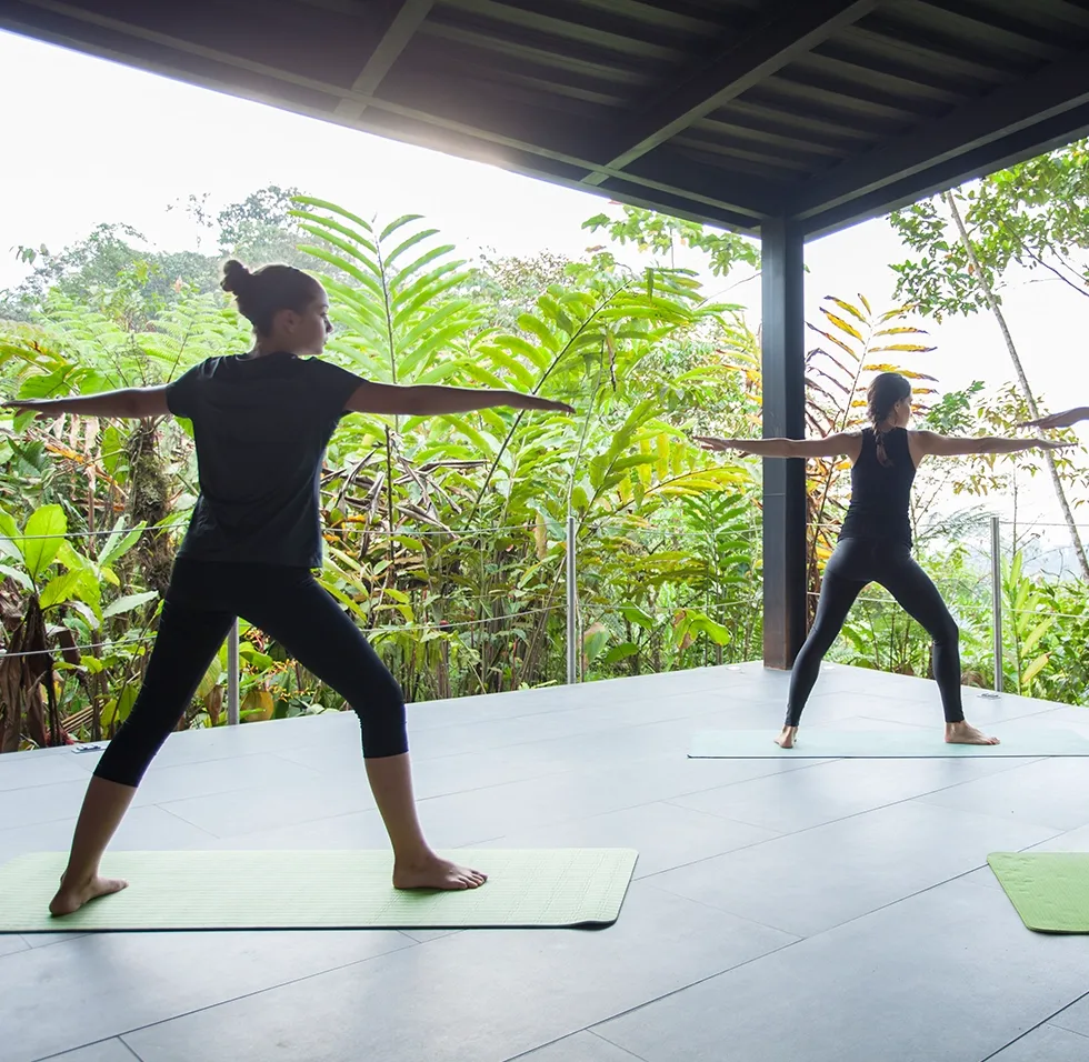 Yoga on a covered deck overlooking tropical vegetation at Mashpi Lodge, Ecuador