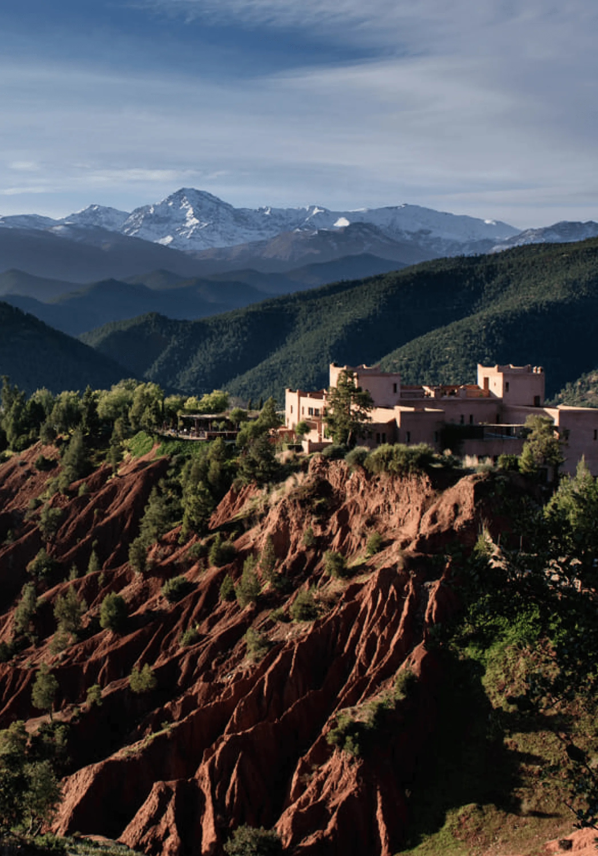 Kasbah perched above a rugged valley with mountains beyond, Ourika Valley, Morocco