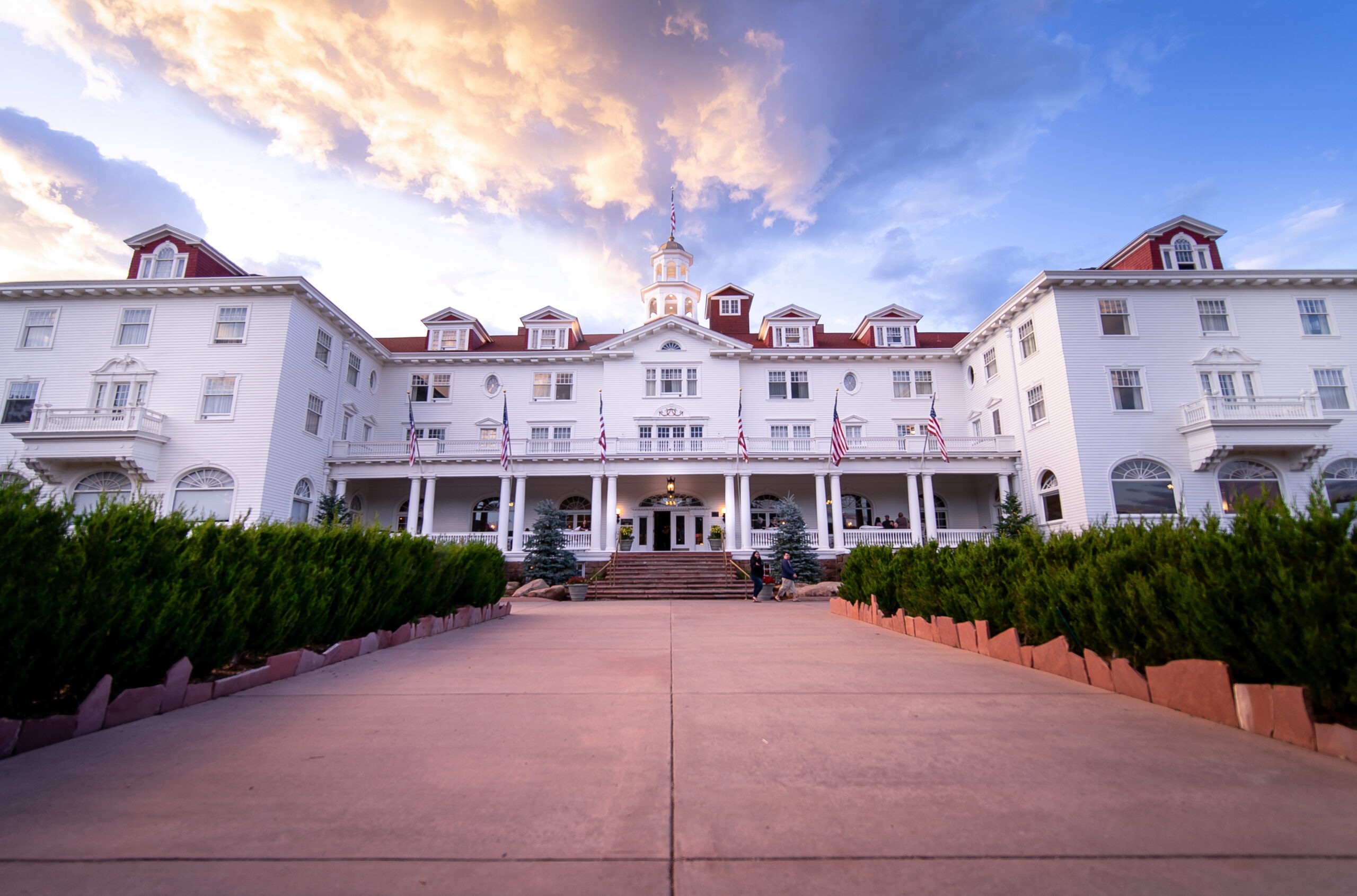 Main hotel facade with red-roofed wings at dusk at The Stanley Hotel, Estes Park, USA