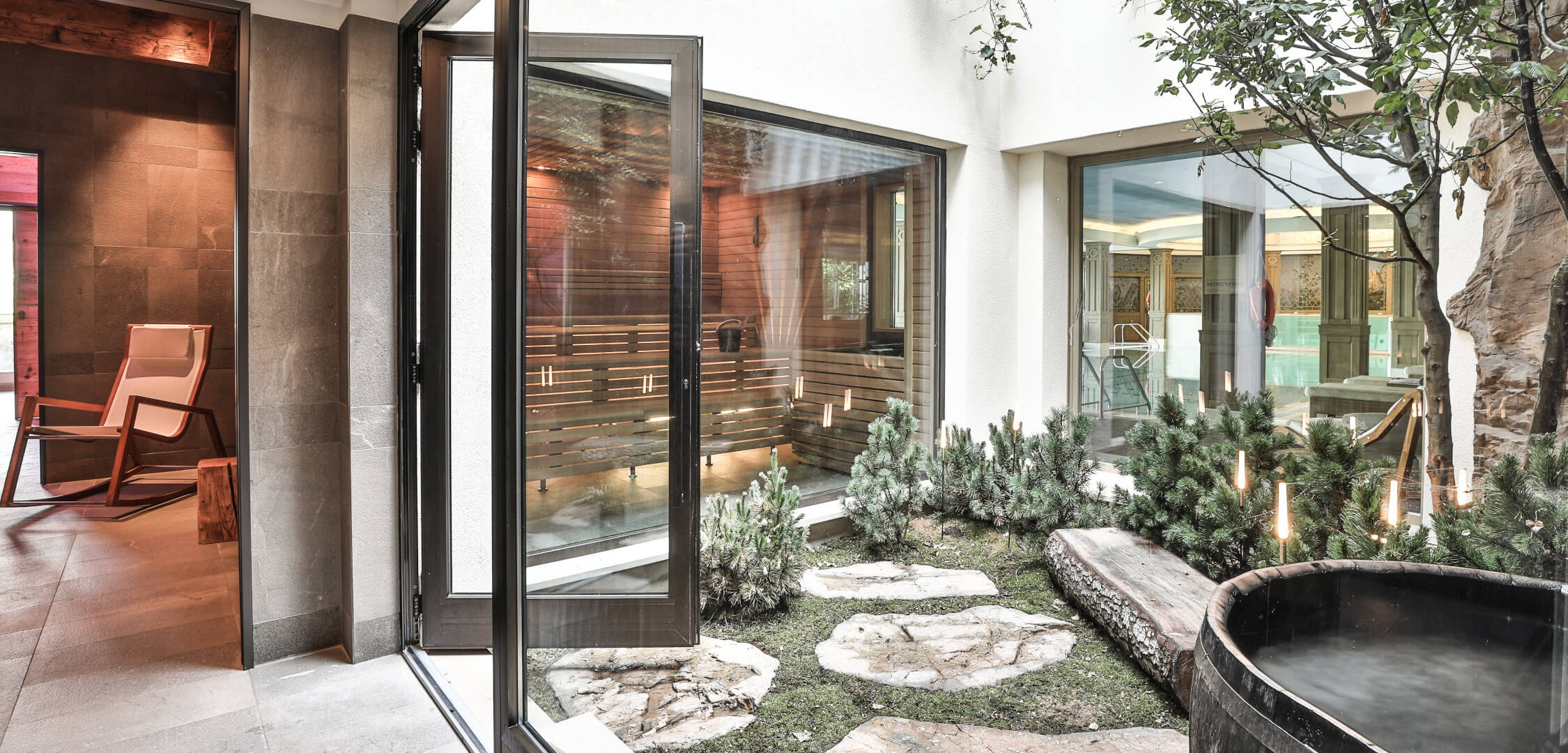 Cristallo spa courtyard with glass-fronted sauna spaces and greenery at Mandarin Oriental Cristallo, Cortina