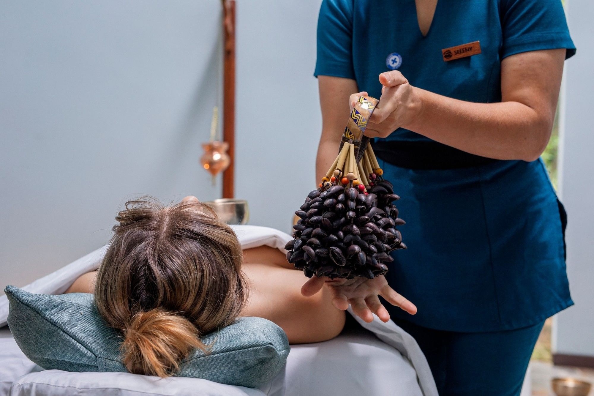Spa therapist treating a guest resting on a massage table, El Silencio Lodge & Spa