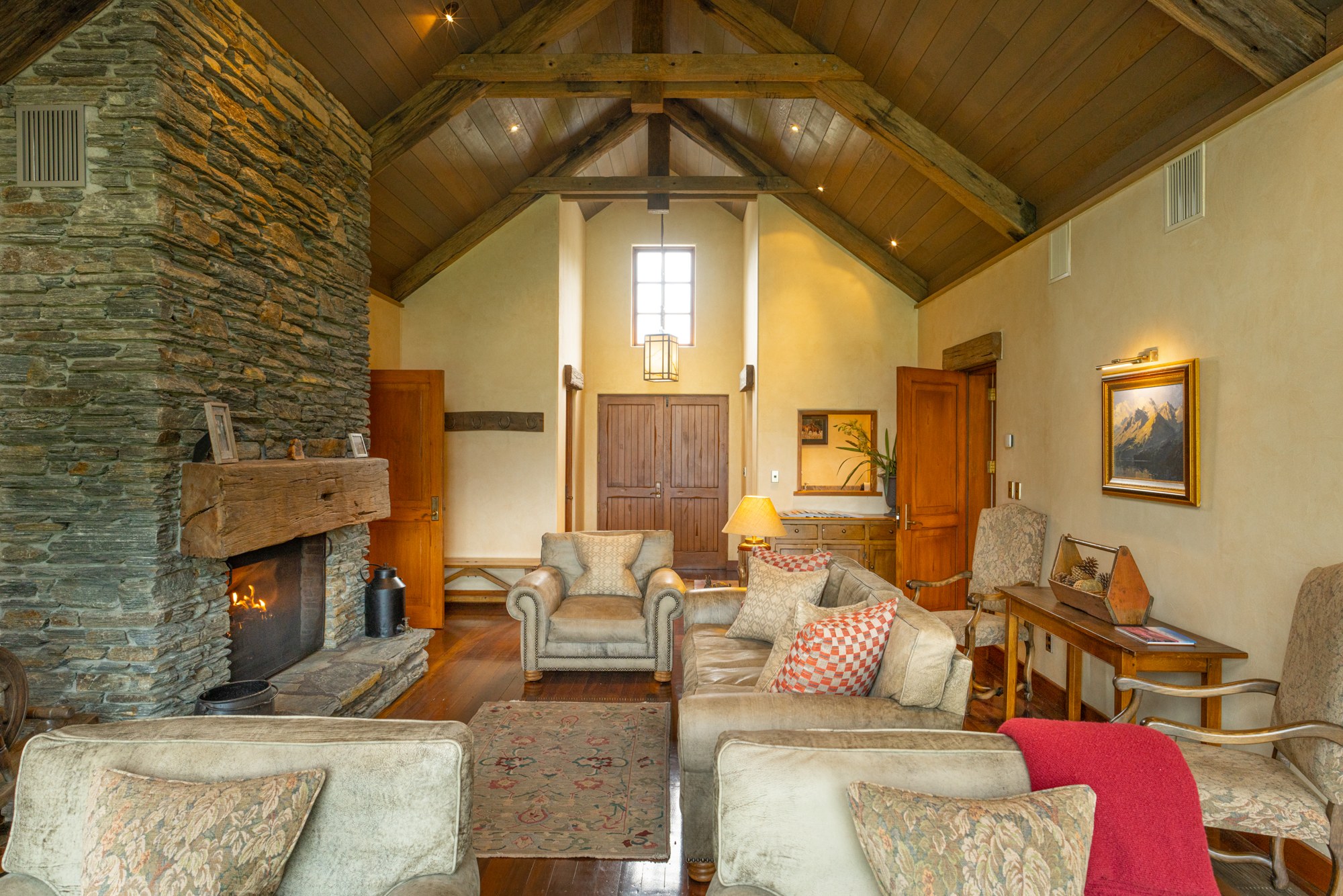 Stone fireplace and timber beams in a chalet stateroom at Blanket Bay