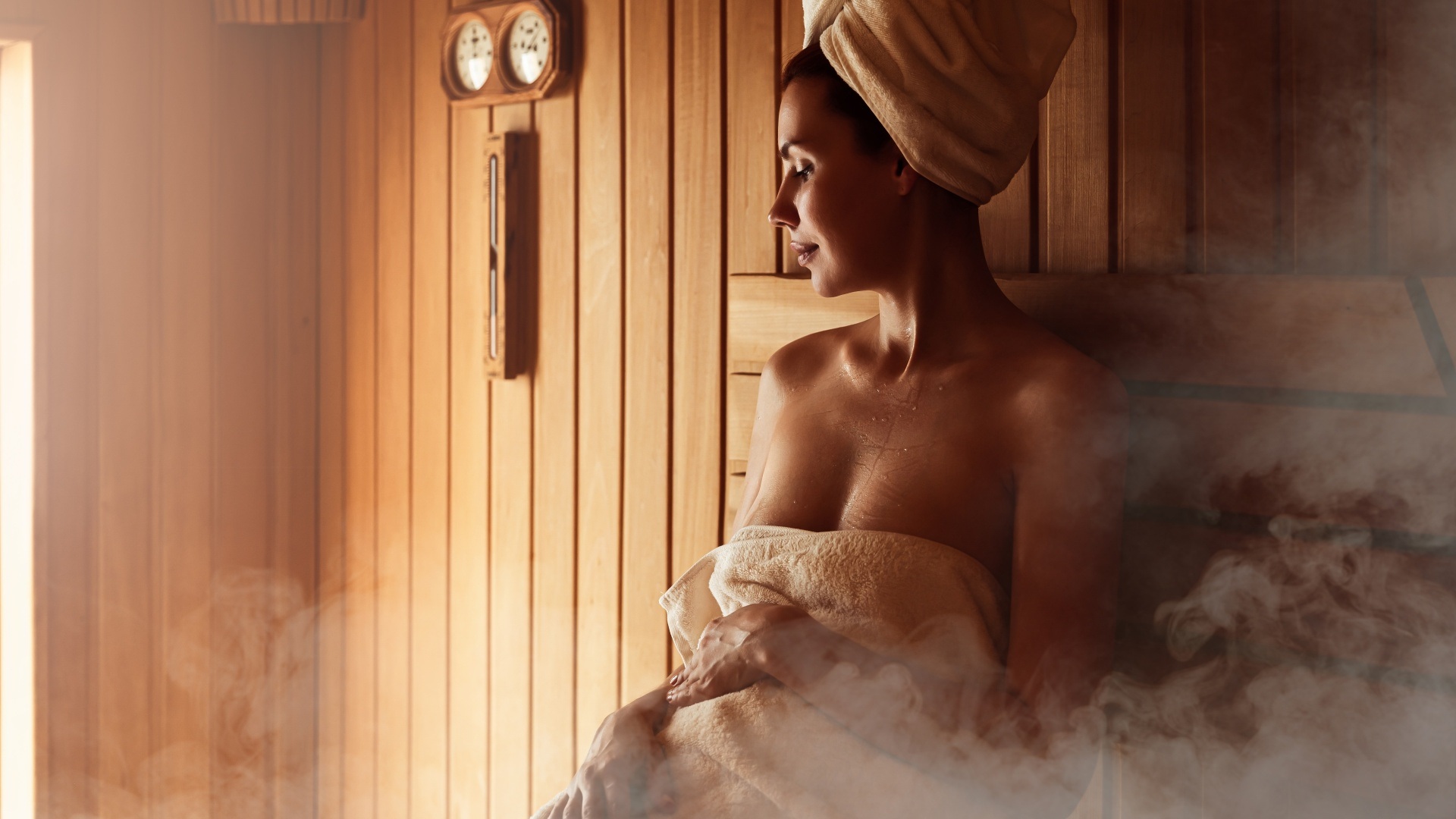 Guest sitting in a wood-lined sauna at Kakslauttanen Arctic Resort, Saariselkä, Finnish Lapland