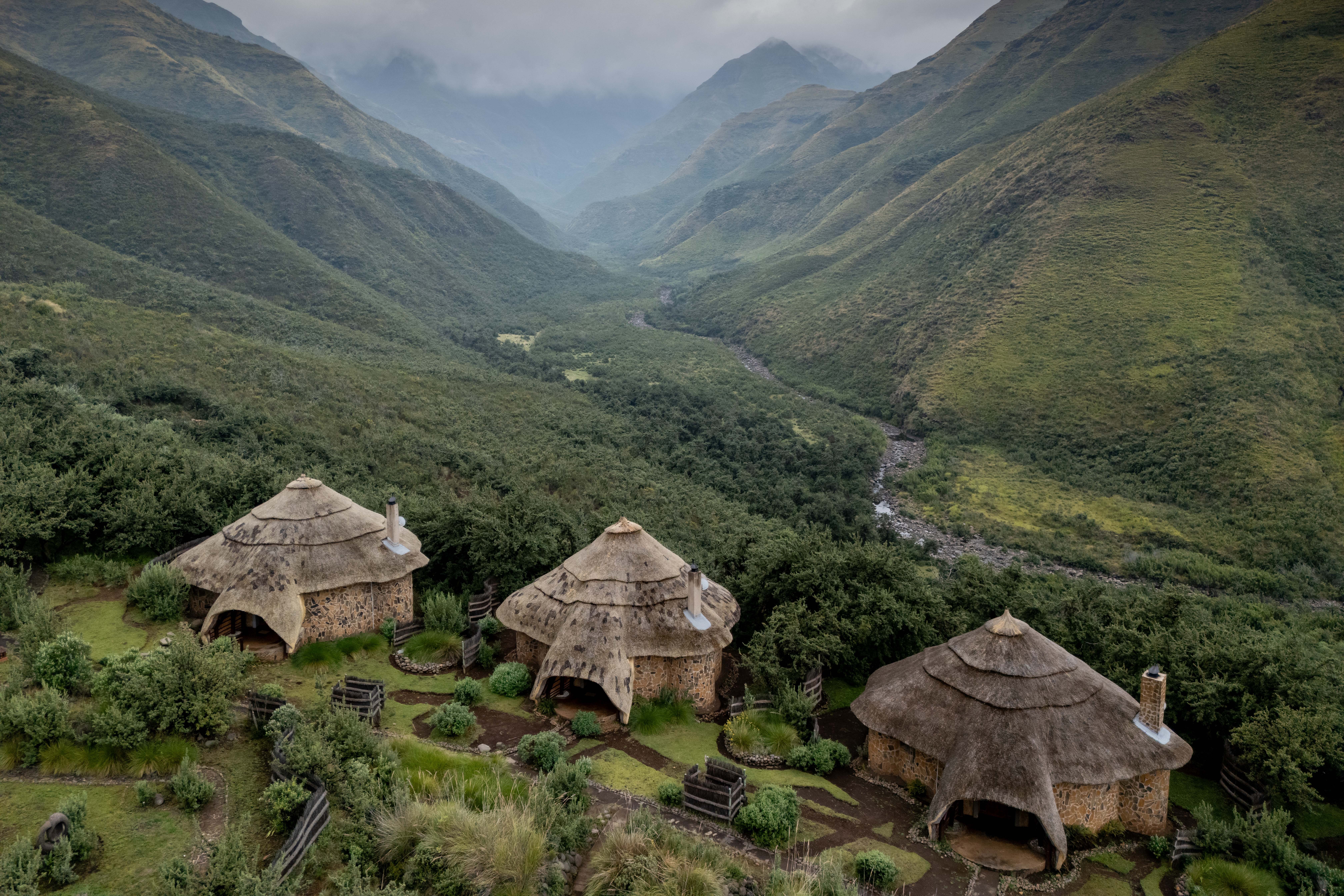 Thatched chalet exteriors overlooking the green valley, Maliba Mountain Lodge, Ts’ehlanyane National Park, Lesotho