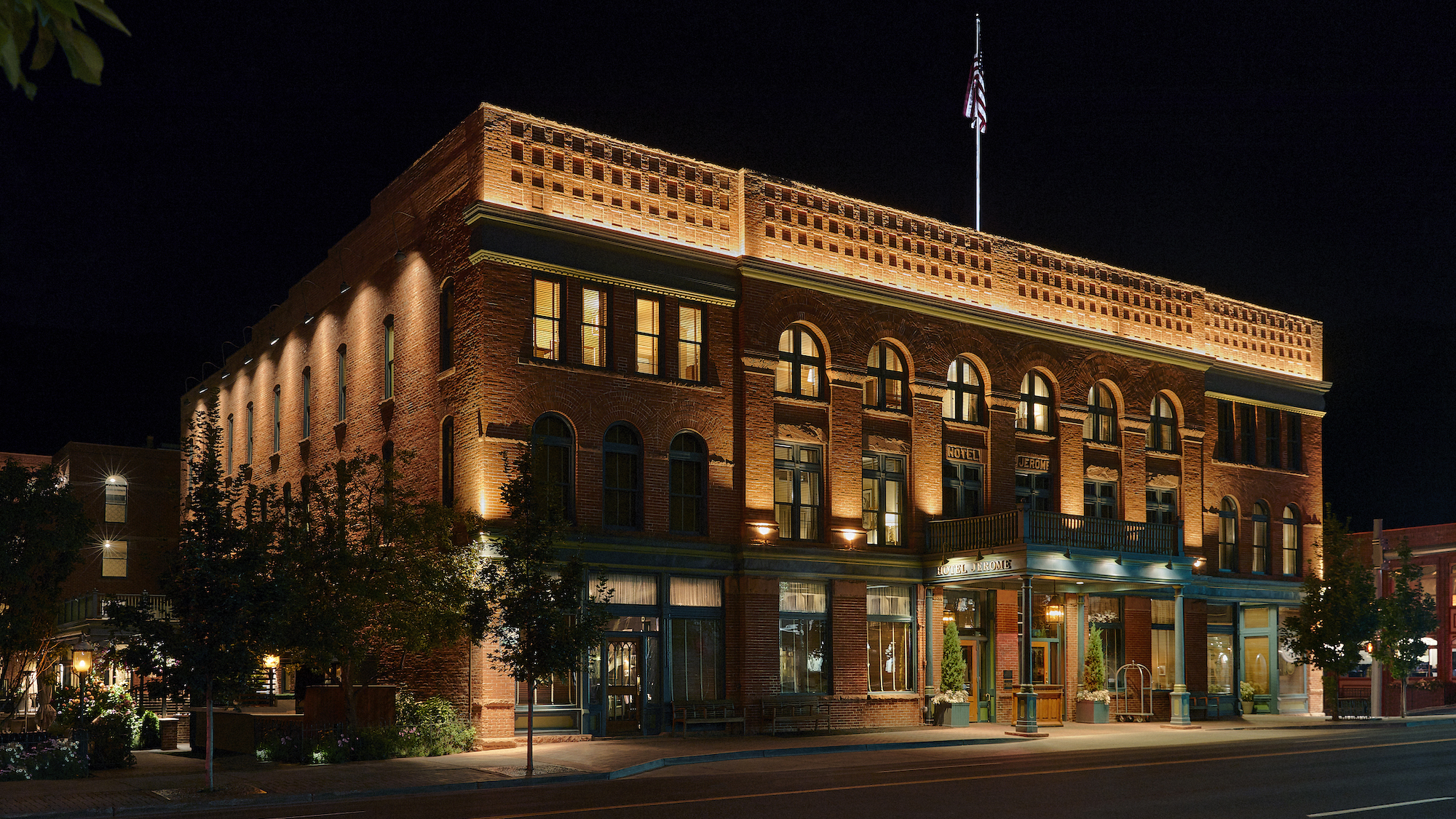 Hotel Jerome's historic brick exterior illuminated at night, Aspen