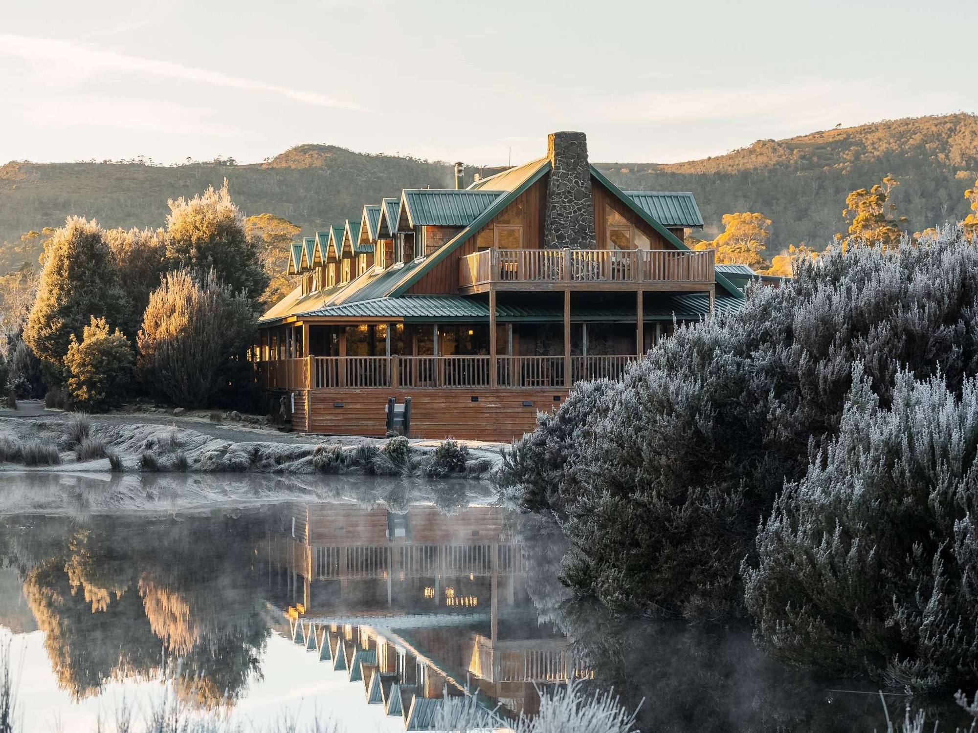Peppers Cradle Mountain Lodge beside a lake with frosted Tasmanian hills beyond