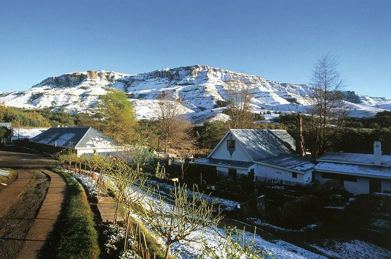 Snow-covered farmhouse exterior and mountain ridge, Cleopatra Mountain Farmhouse, Drakensberg, KwaZulu-Natal, South Africa