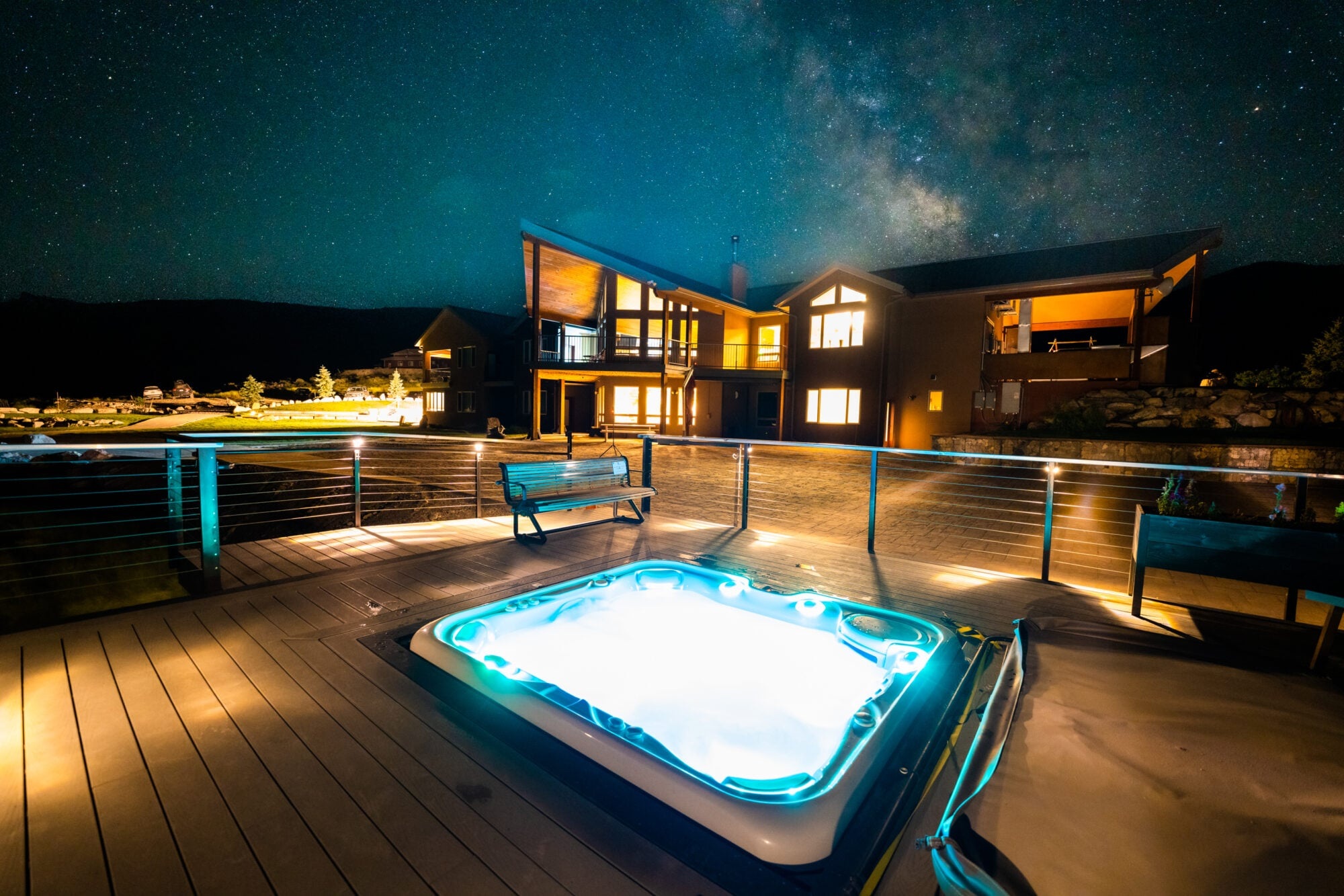 Illuminated outdoor hot tub beside the lodge at night at Ruby 360 Lodge, Lamoille, USA