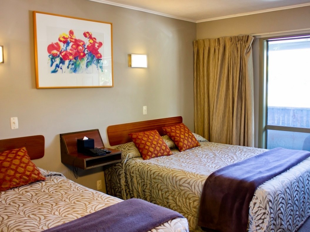 Twin guest room at The Godley Hotel with colourful cushions