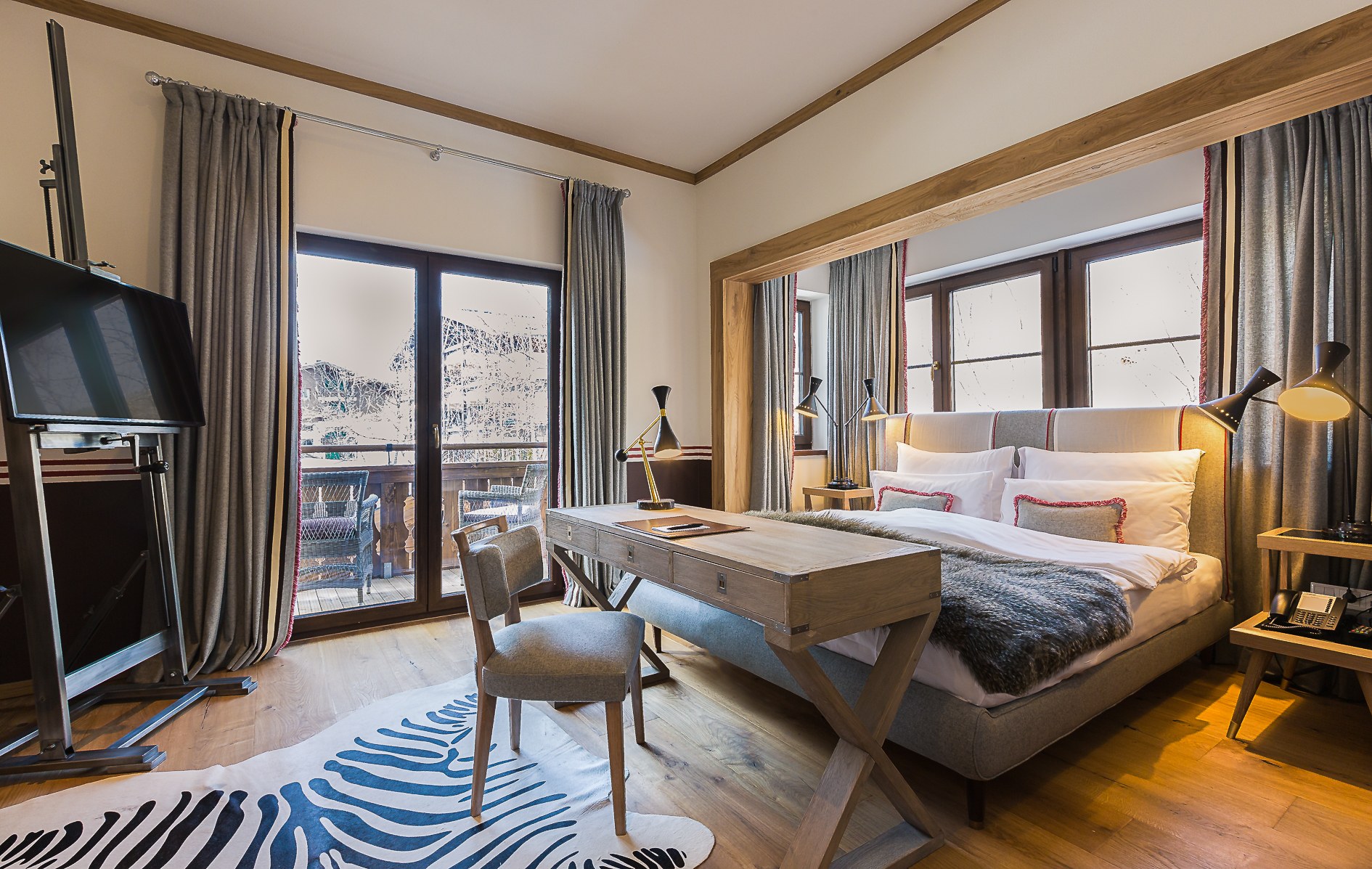 Alpine suite bedroom and sitting area opening onto a balcony at House of Hütter – Wachtelhof, Hinterthal, Austria