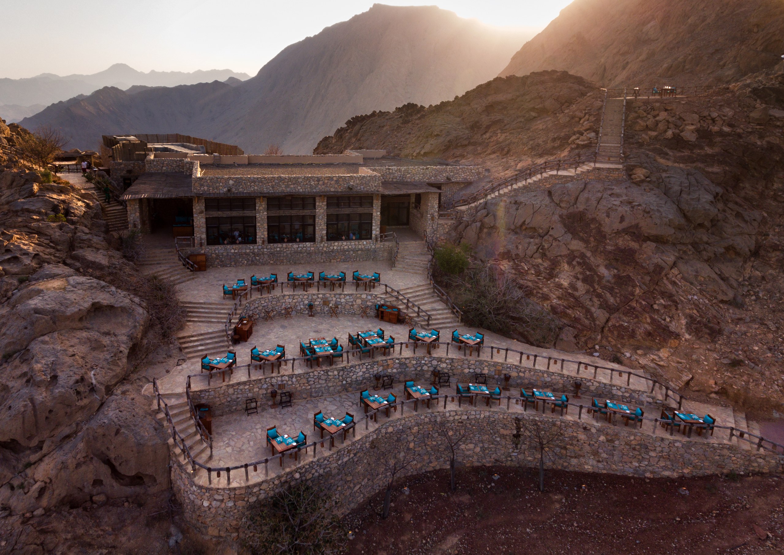Sense on the Edge restaurant terraces among the mountains at sunset at Six Senses Zighy Bay.
