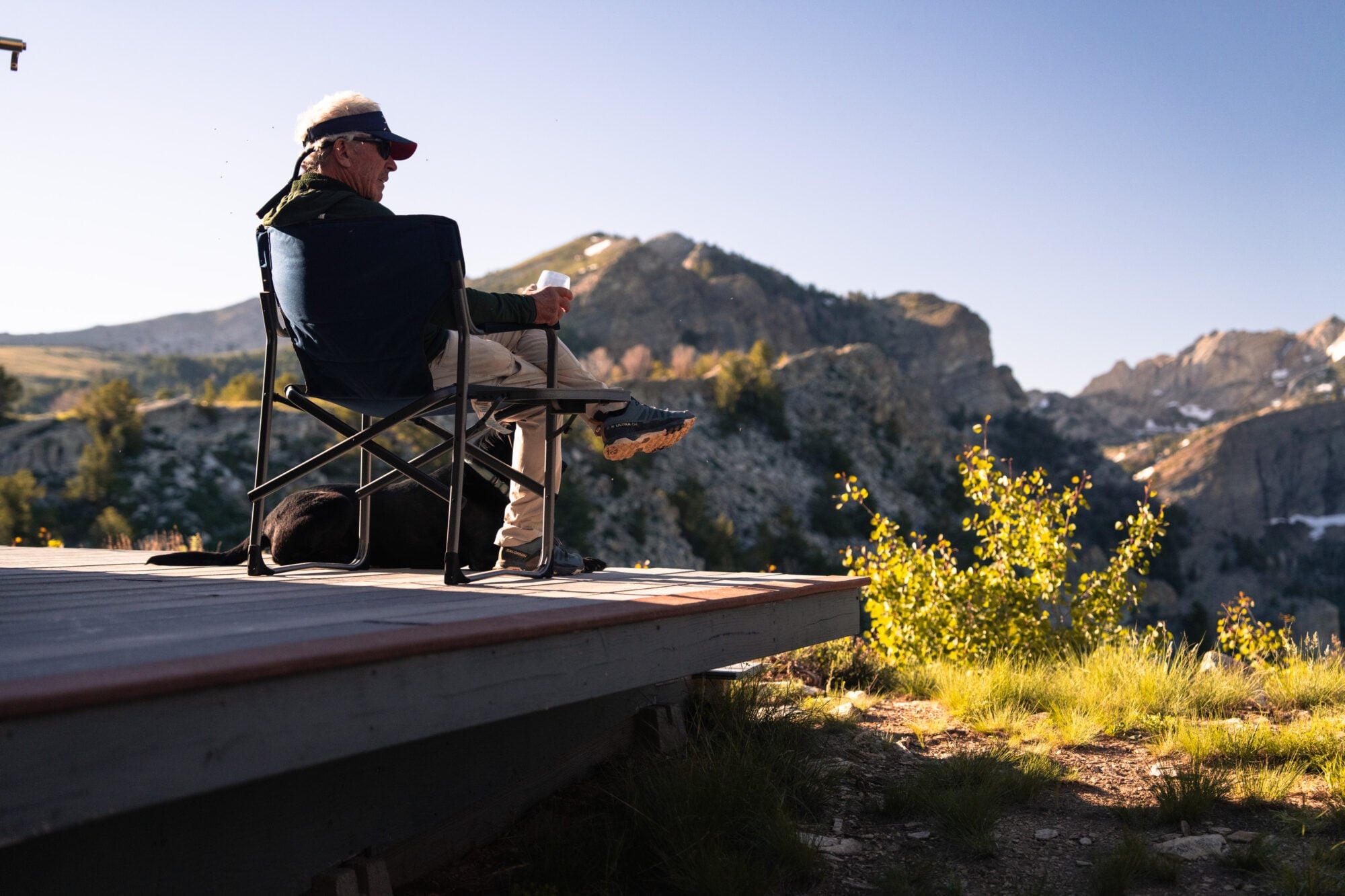 Guest seated on a deck overlooking rugged mountain scenery at Ruby 360 Lodge, Lamoille, USA