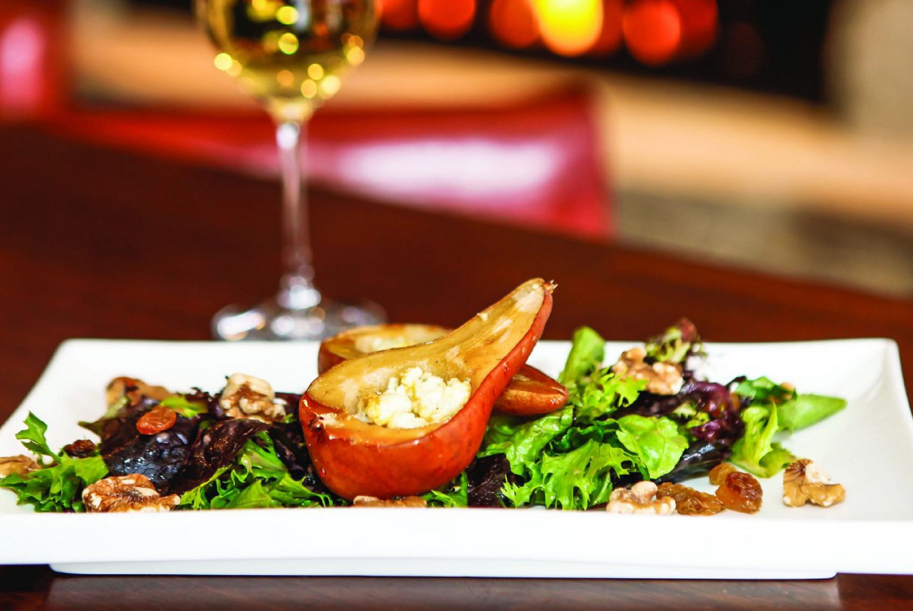 Plated salad and a glass of wine at The Osprey Fireside Grill in Beaver Creek.