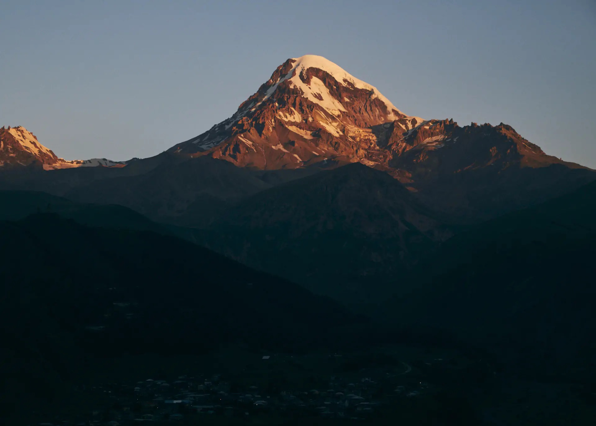 Mountain at sunset above the dark valley near Rooms Kazbegi.