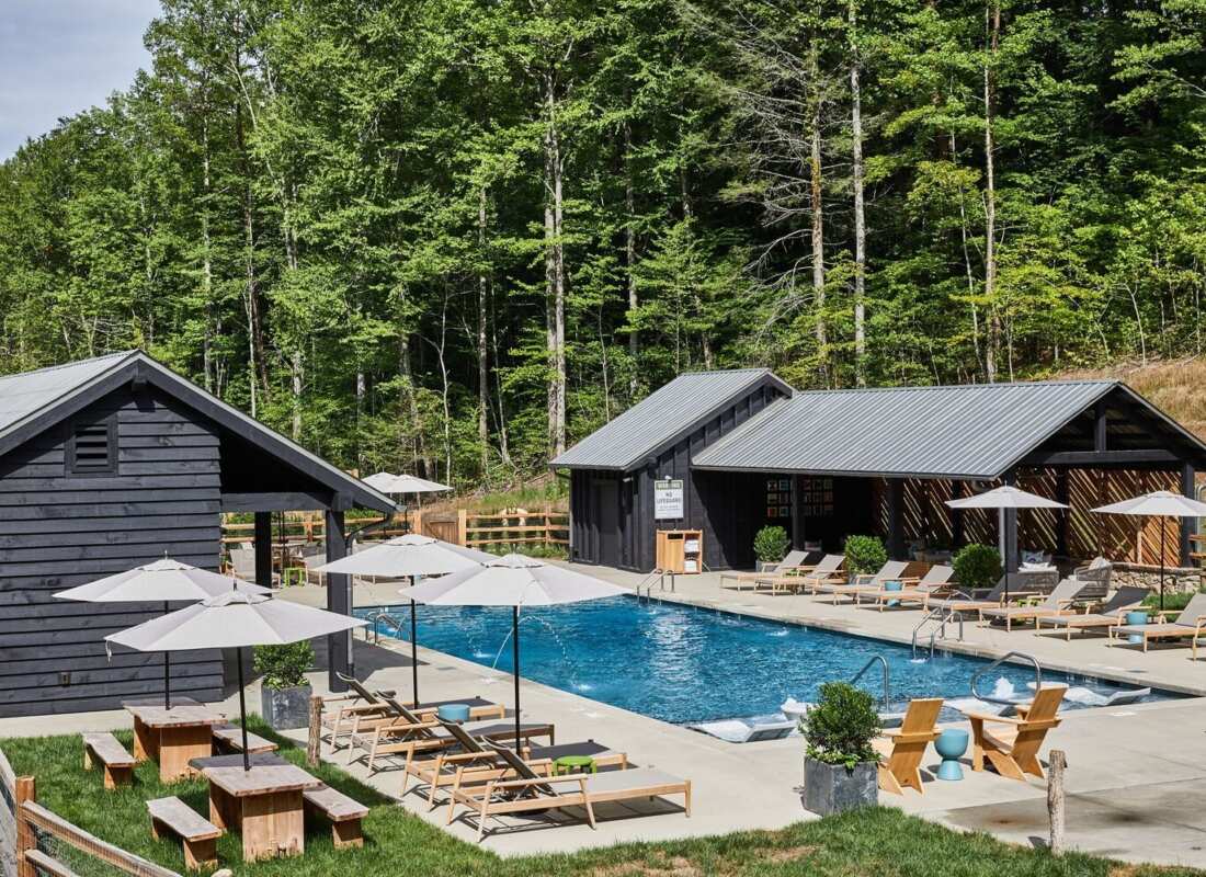 Outdoor Valley pool with lounge chairs, umbrellas and woodland at Blackberry Mountain, Walland, USA