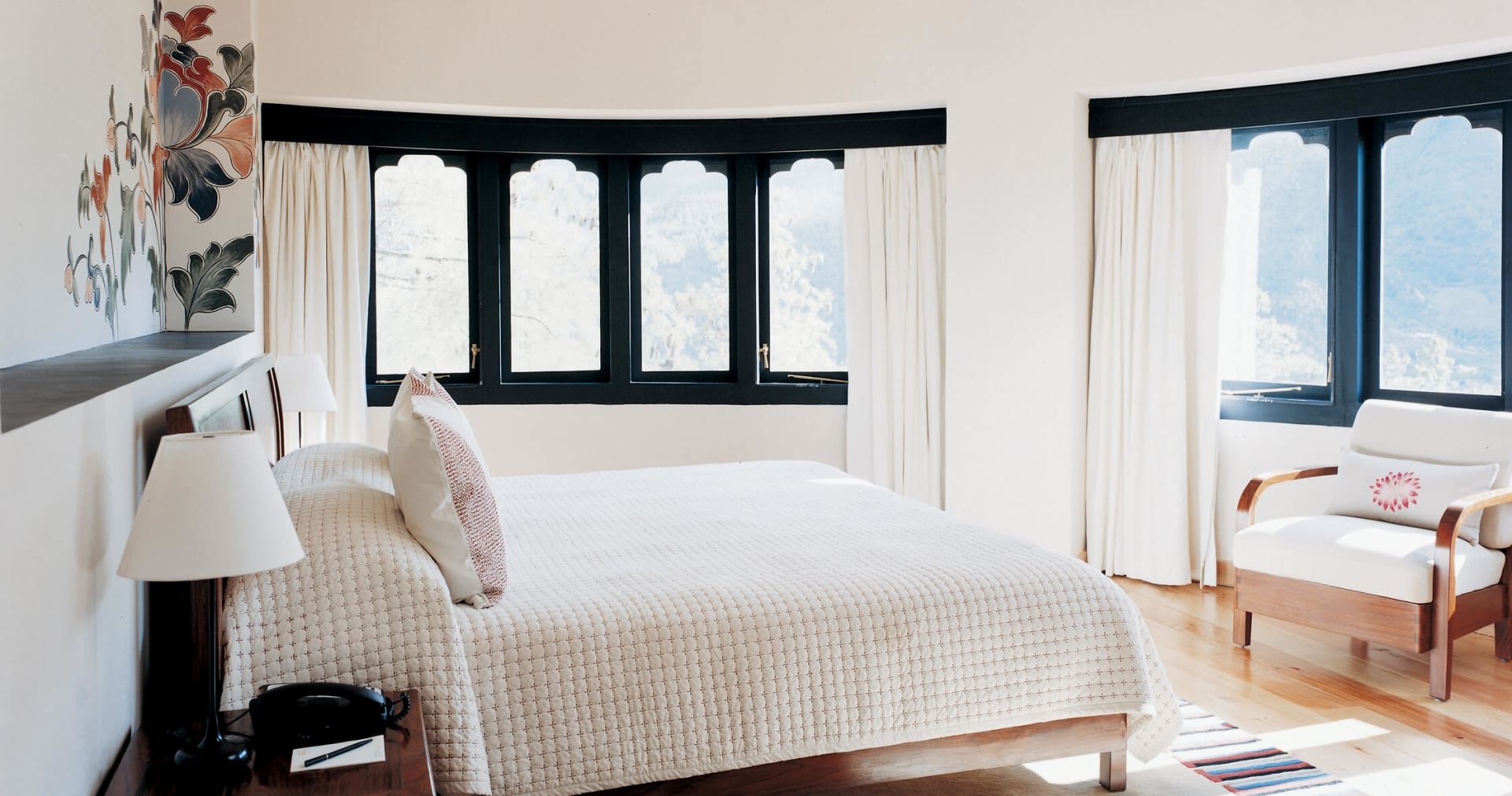 Suite bedroom with large windows and a sitting area at COMO Uma Paro, Paro, Bhutan
