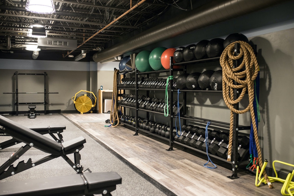 Gravity Haus Breckenridge gym with dumbbells, weight benches, exercise balls and training ropes.