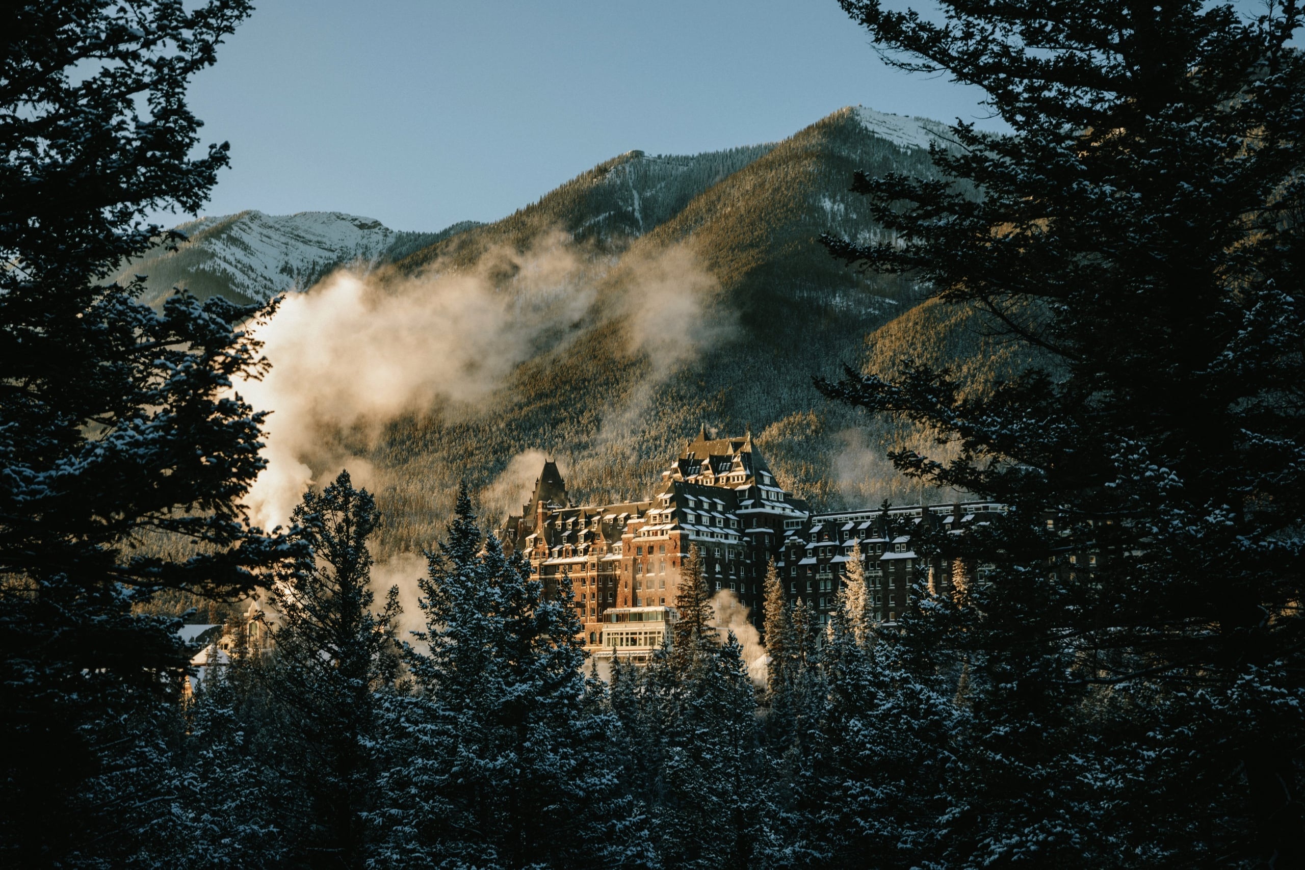 Castle-like hotel among forest and misty mountains at Fairmont Banff Springs, Banff, Canada