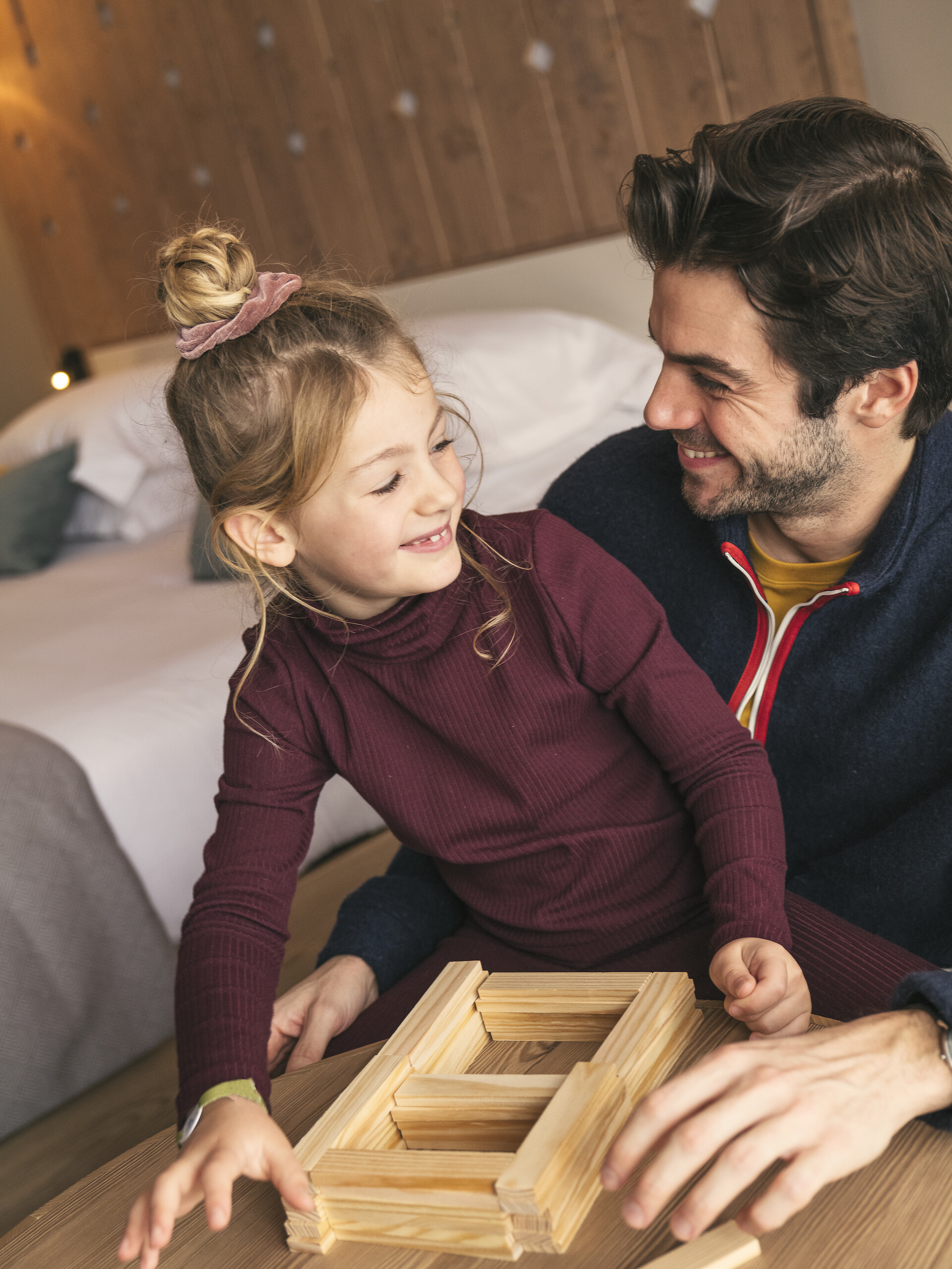 Young child playing with wooden blocks beside an adult, from Club Med Tignes family activities