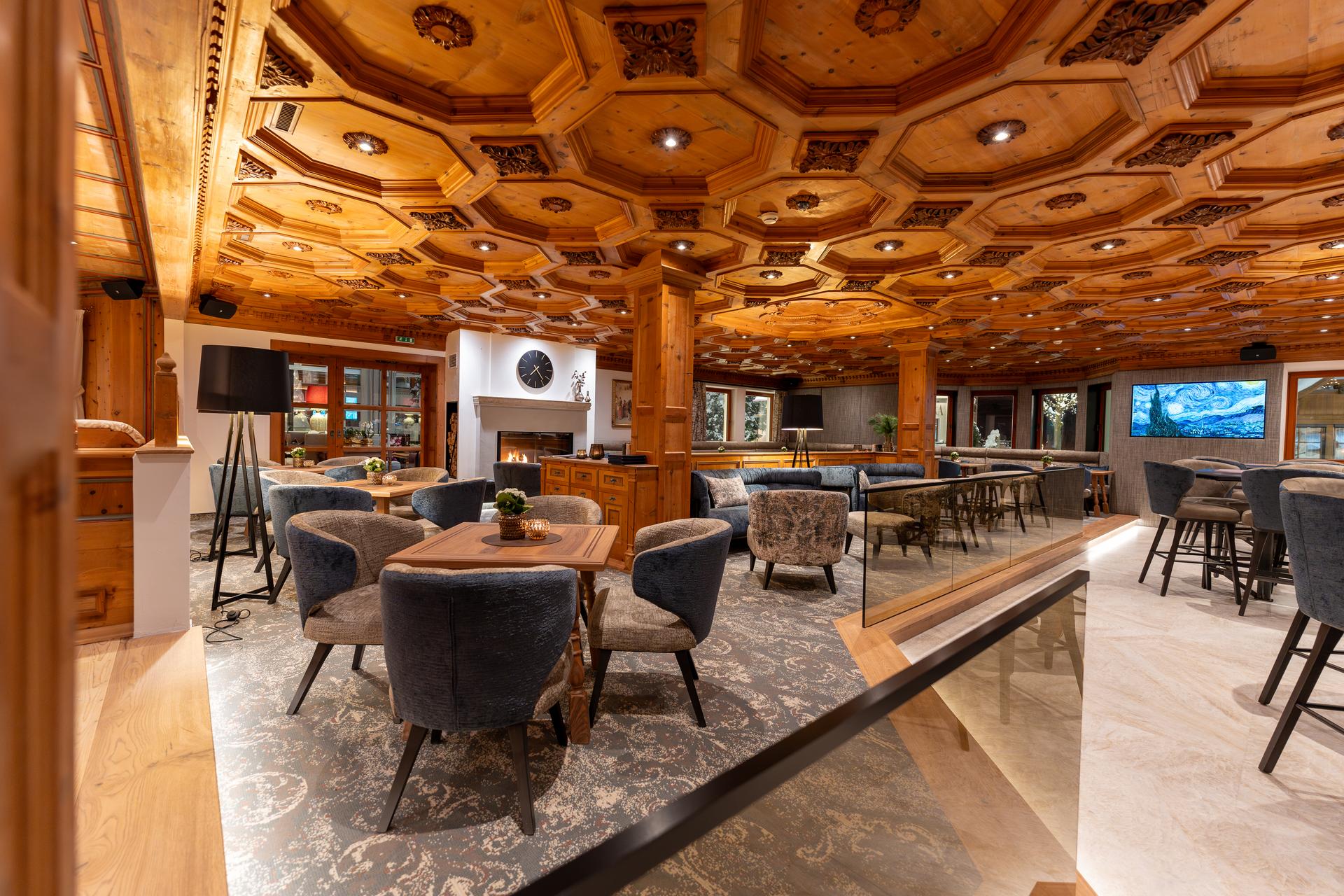 Grand lounge with carved wooden ceiling, Trofana Royal, Ischgl, Austria