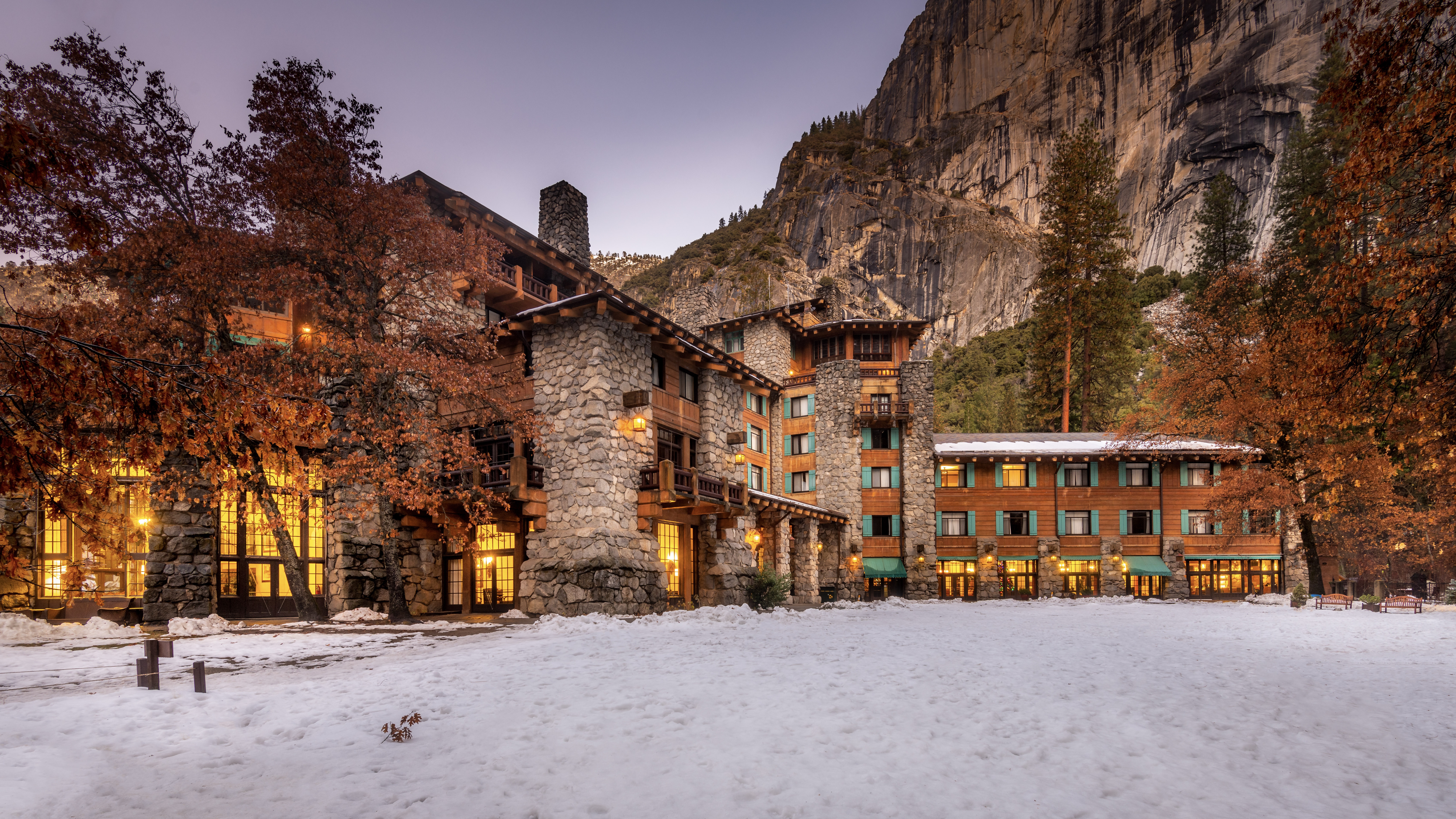 The Ahwahnee illuminated at dusk beneath Yosemite cliffs in winter, Yosemite National Park, USA