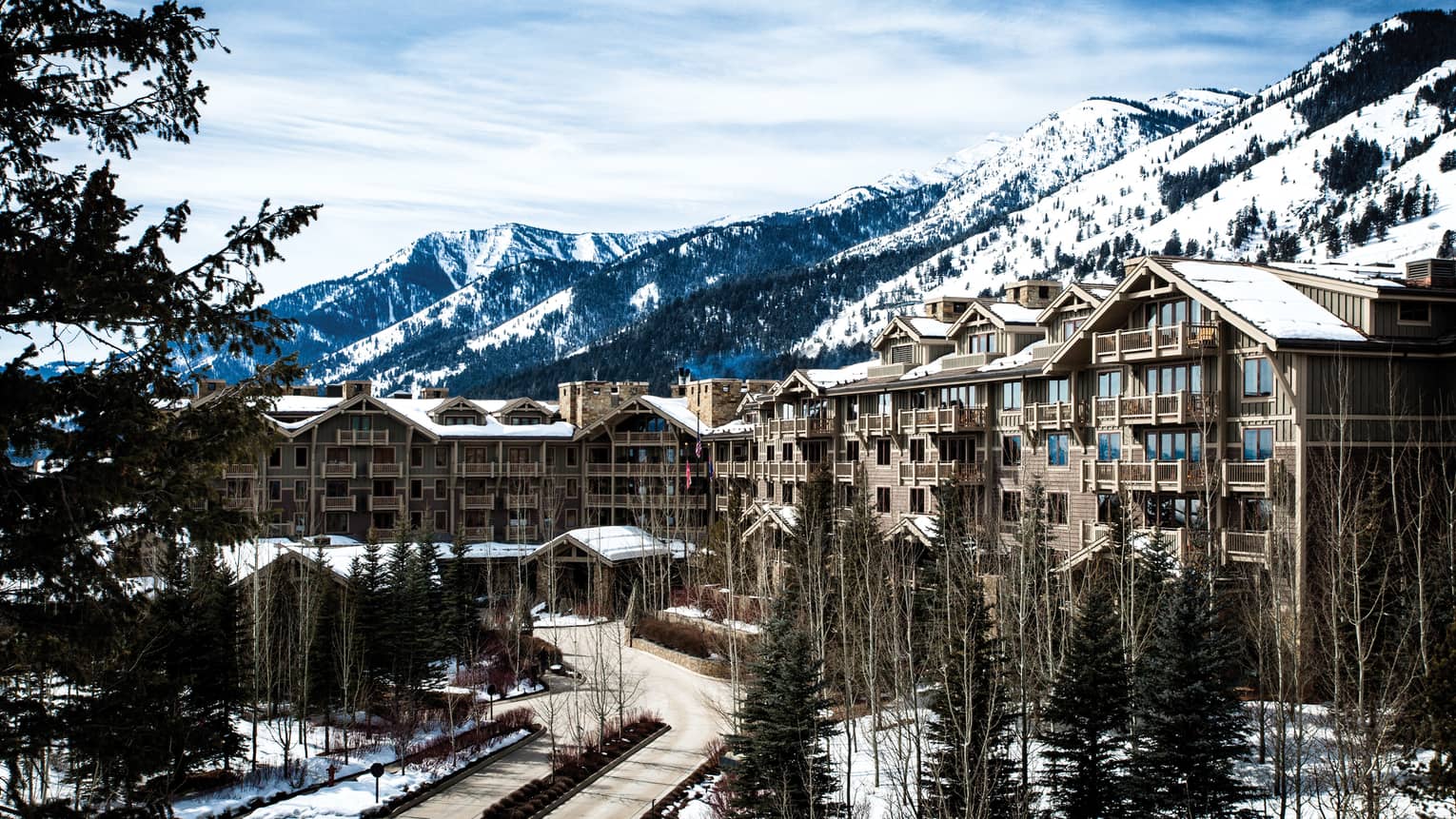 Snow-covered hotel exterior beneath the mountains, Four Seasons Resort Jackson Hole, Teton Village, USA