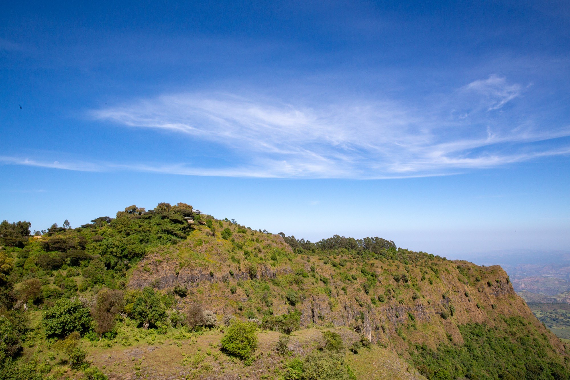 Limalimo Lodge buildings on a green ridge above the Simien escarpment.