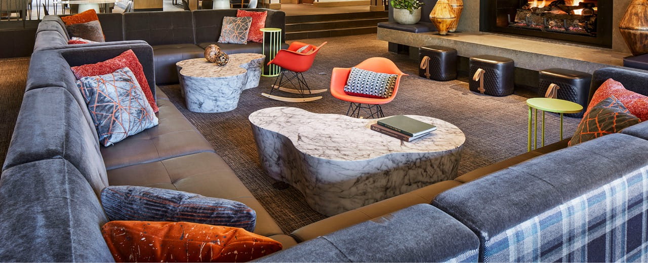 Colourful sofas and stone coffee tables in the Limelight Hotel Snowmass lounge.
