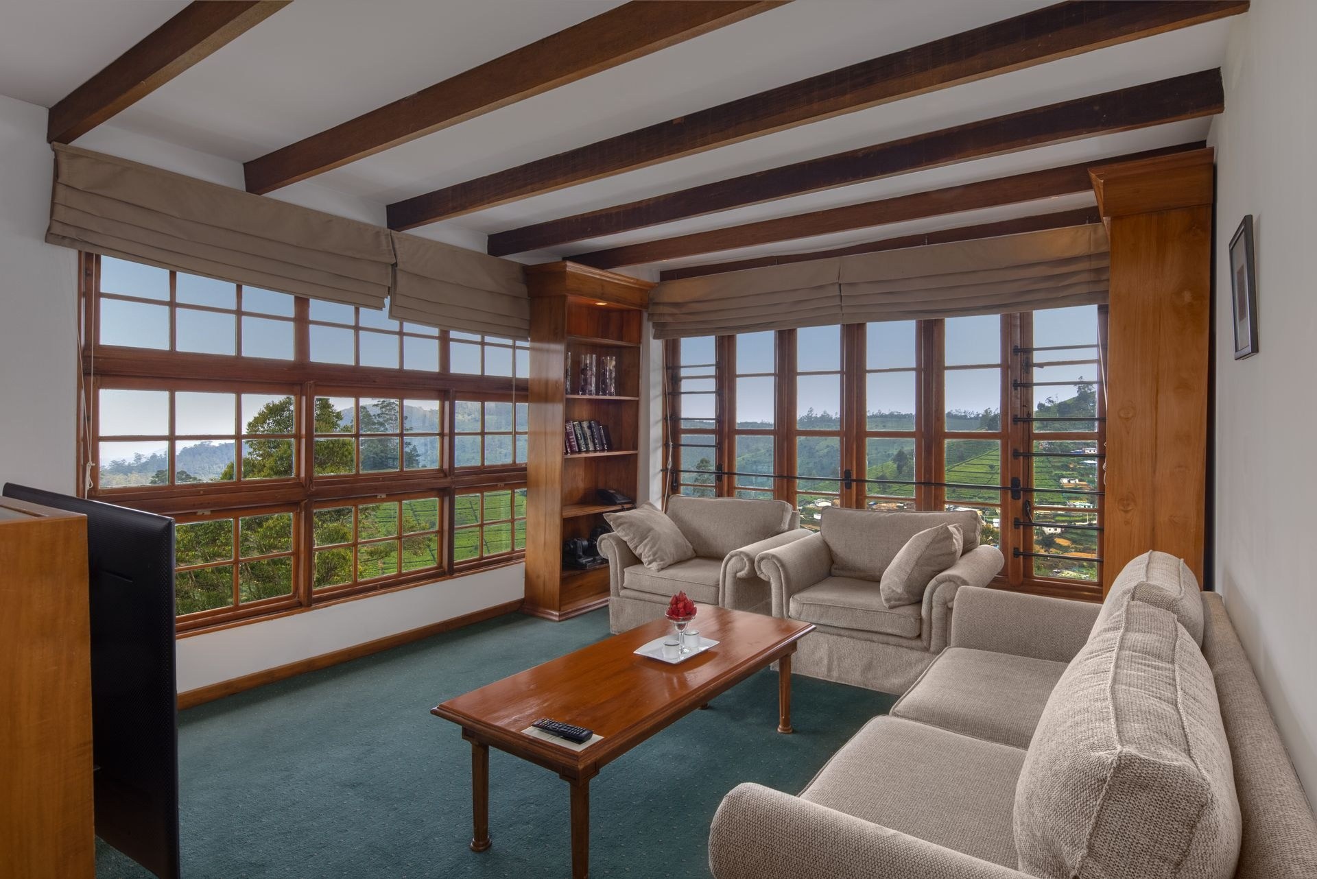 Suite sitting area with wide windows overlooking green tea-country hills, Heritance Tea Factory