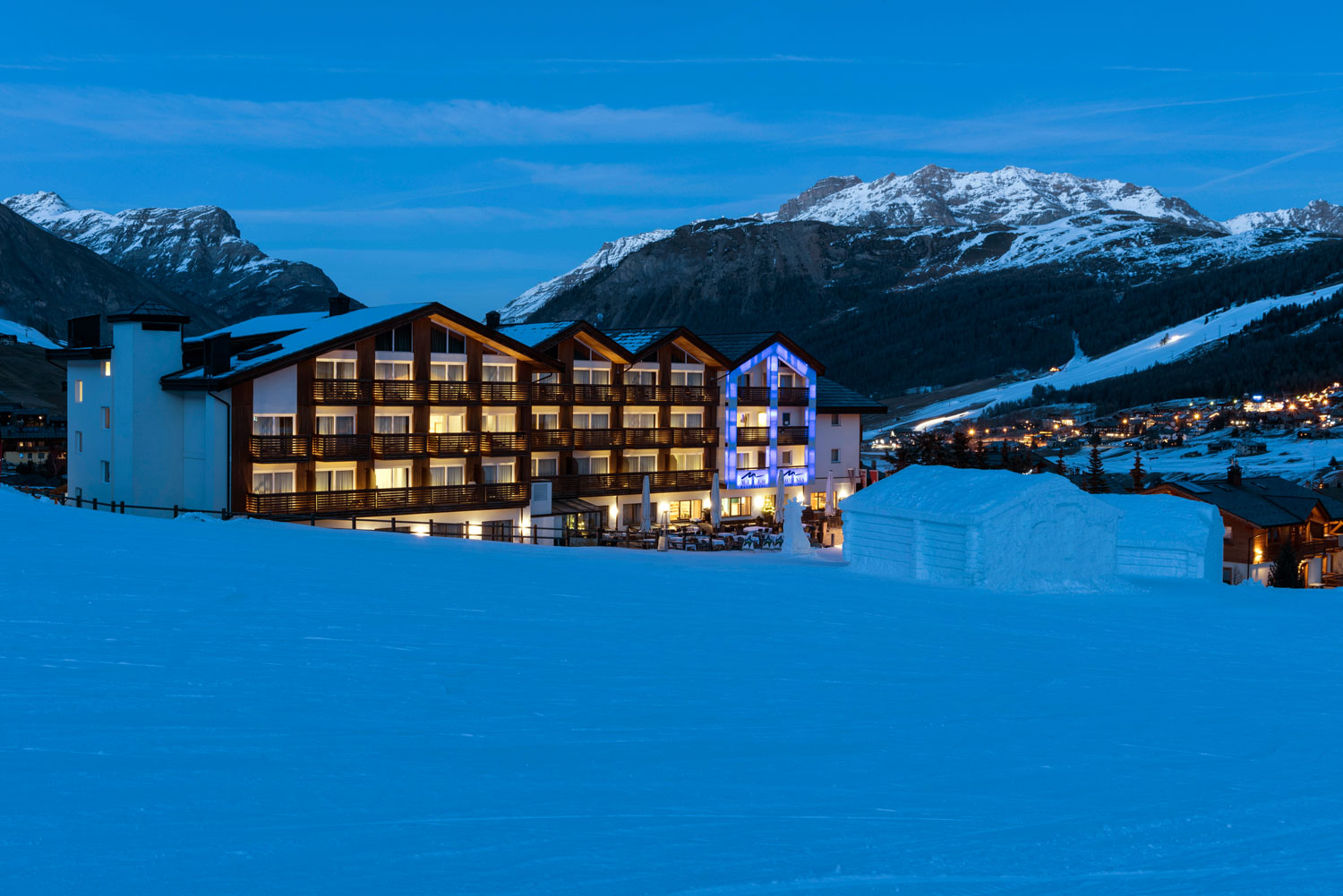Winter mountain setting and illuminated hotel at dusk, Lac Salin Spa & Mountain Resort, Livigno, Italy