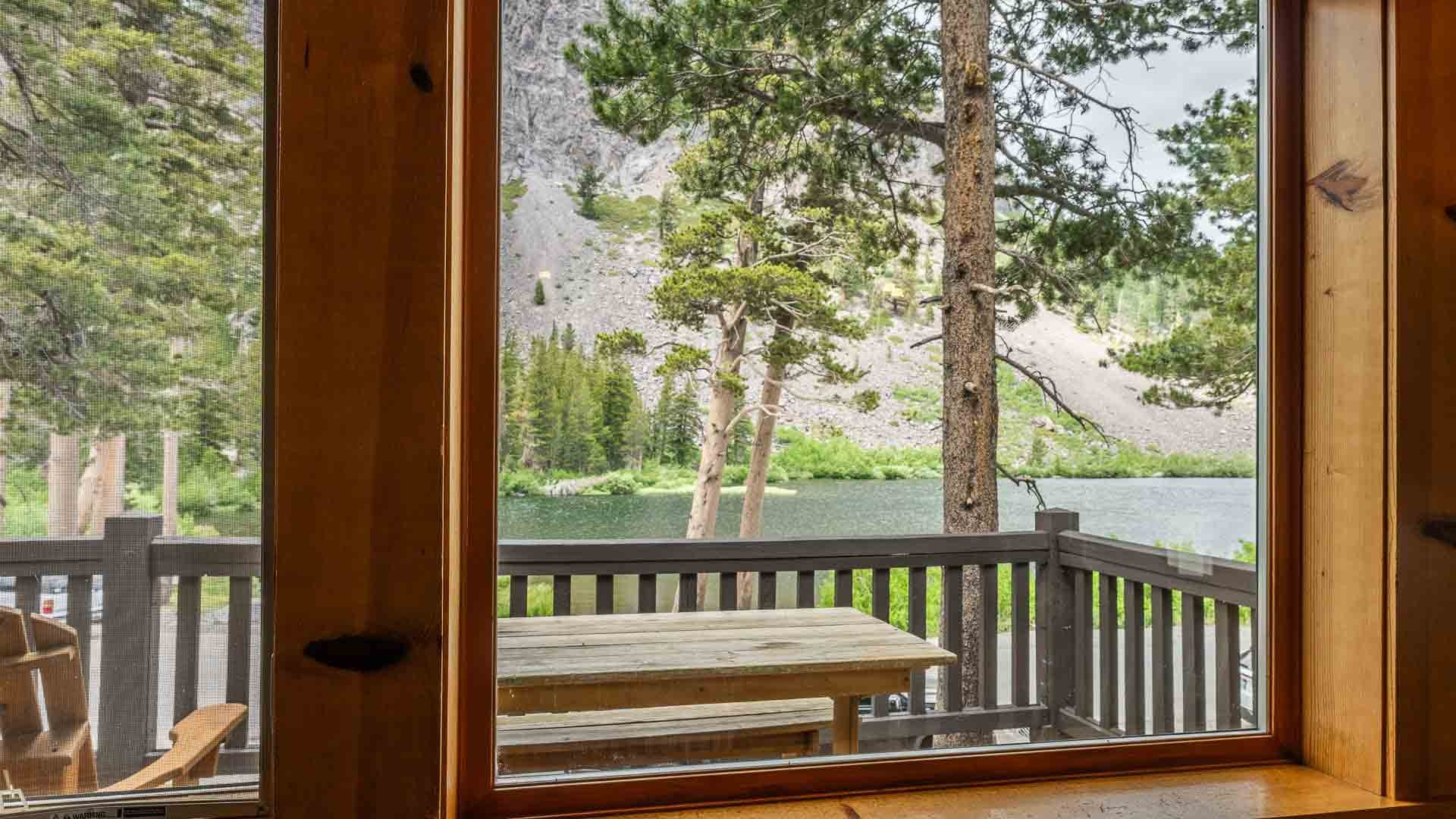 View through cabin doors toward a deck and the lake at Tamarack Lodge & Resort, Mammoth Lakes, USA