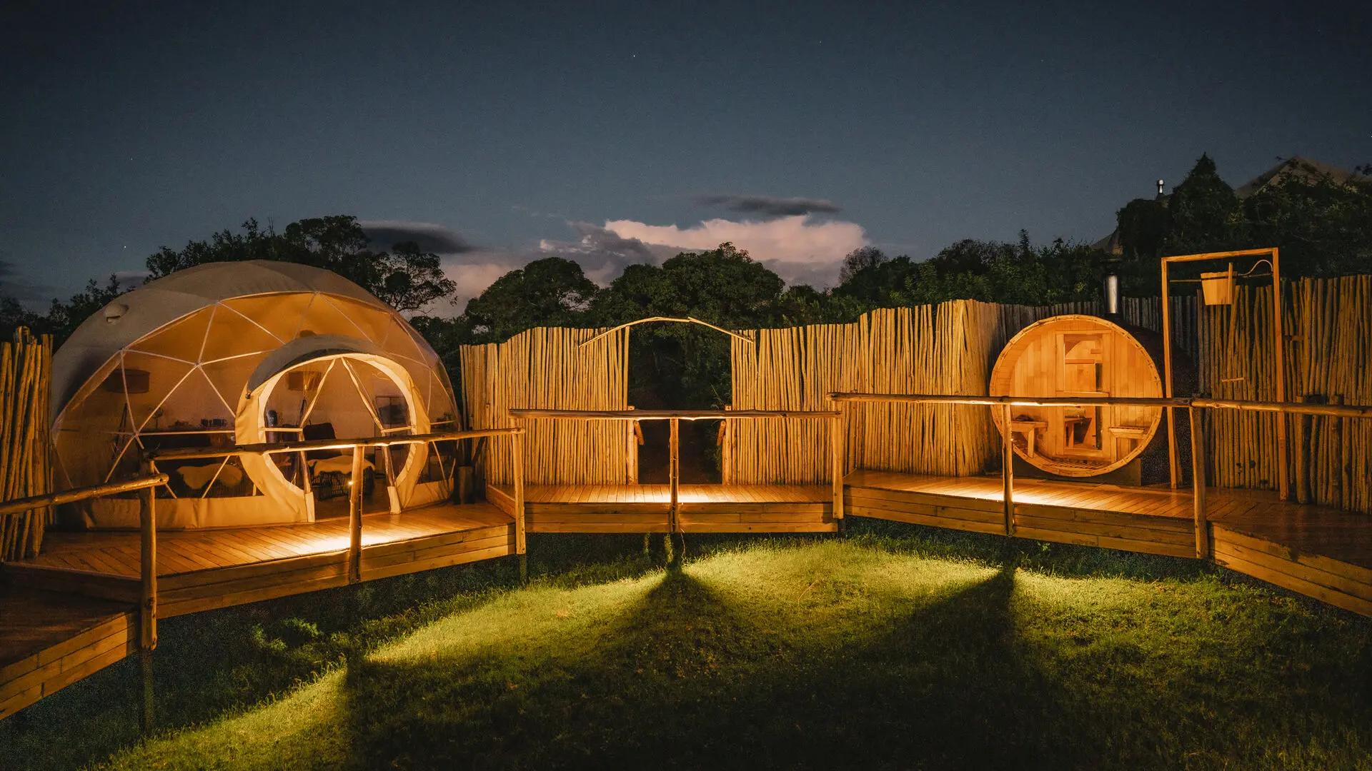 Illuminated spa domes and wooden decks at night, The Highlands, Asilia, Ngorongoro Conservation Area, Tanzania