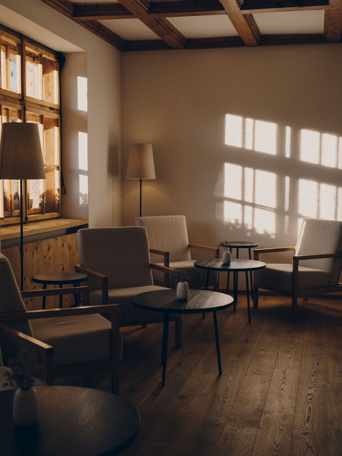 A sunlit lounge with timber beams and seating inside at FORESTIS, Dolomites, Italy