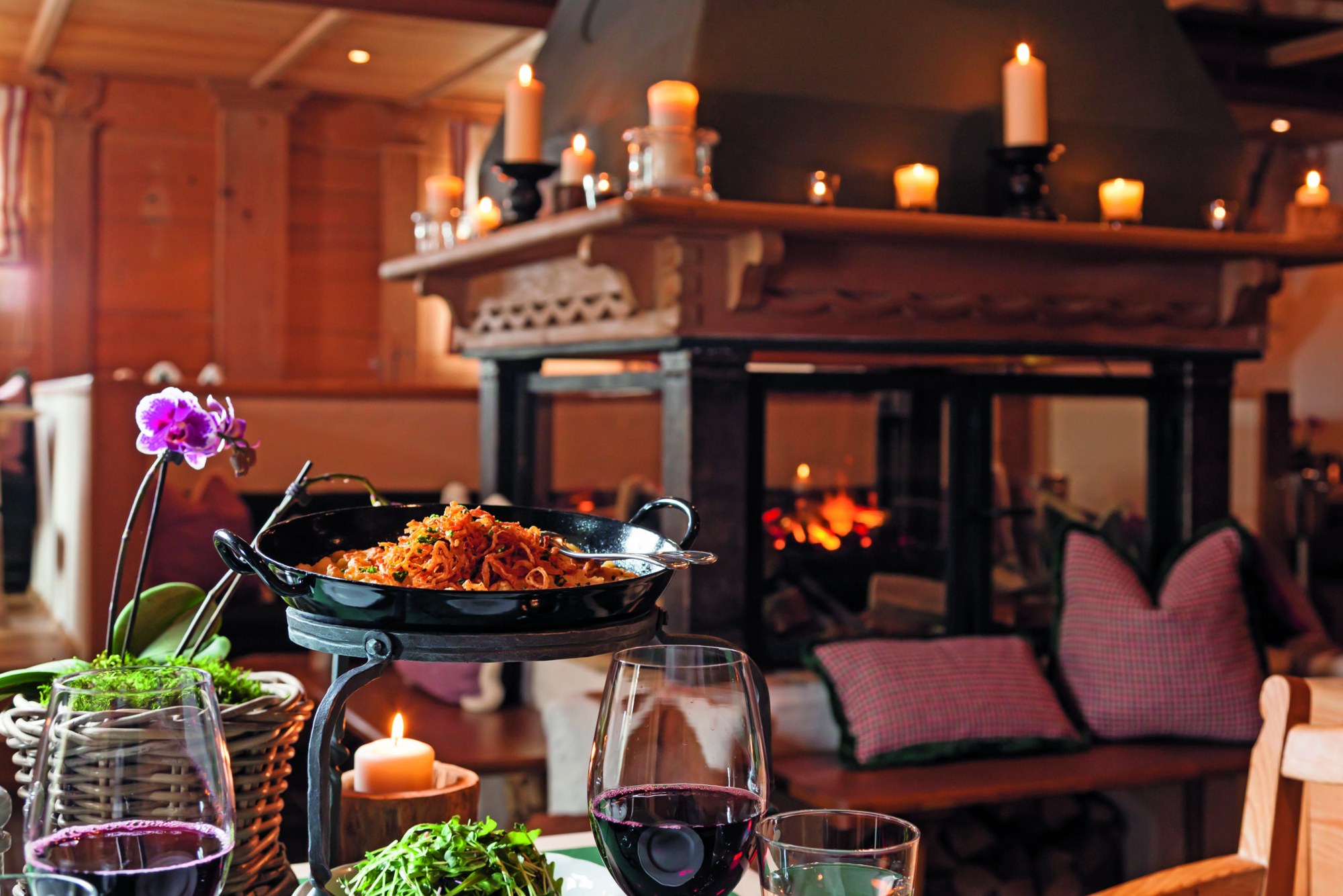 Candlelit dining setting with food, wine and a fireplace at House of Hütter – Wachtelhof, Hinterthal, Austria
