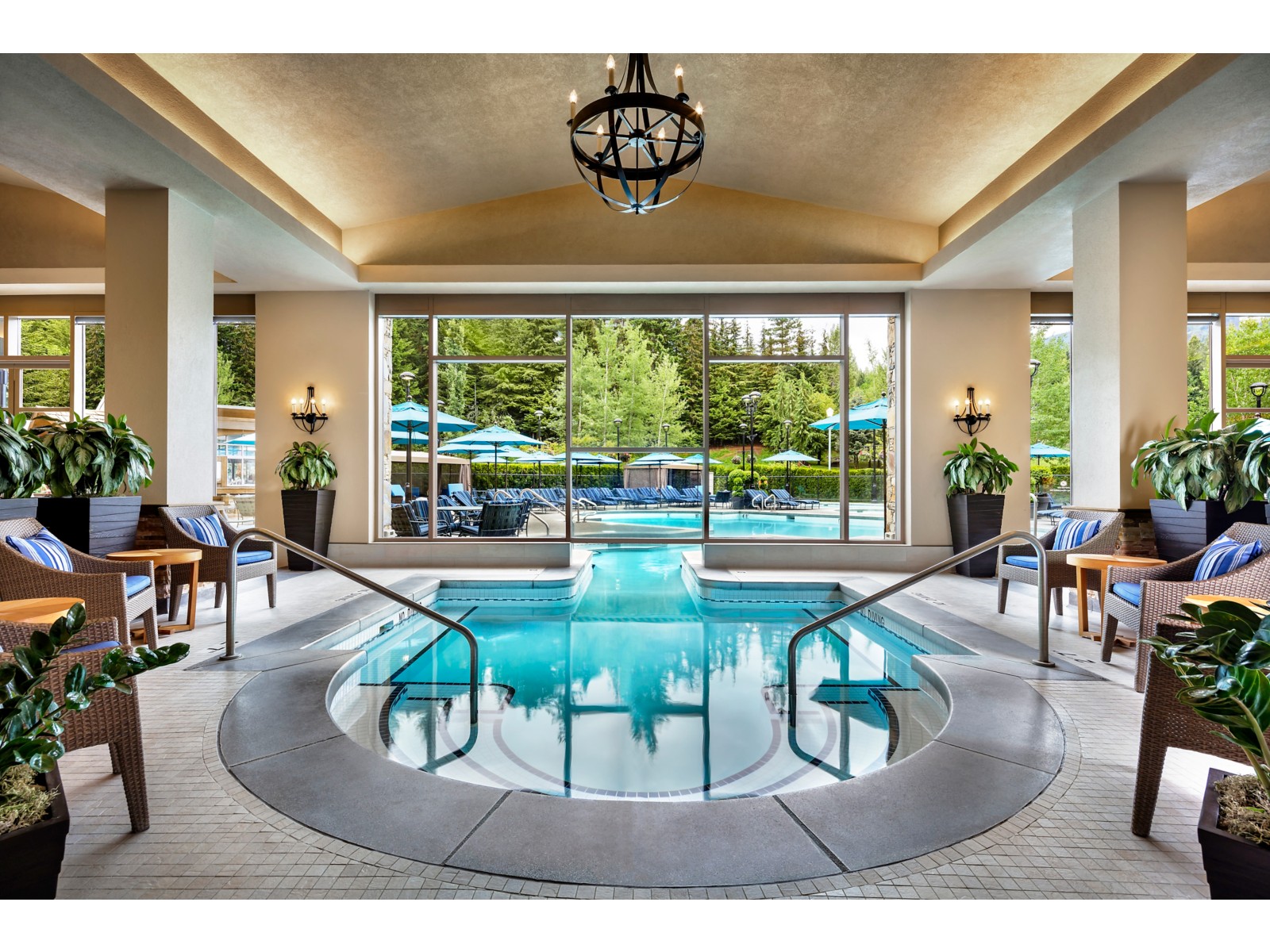Indoor swimming pool with surrounding lounge seating at Fairmont Chateau Whistler, British Columbia, Canada