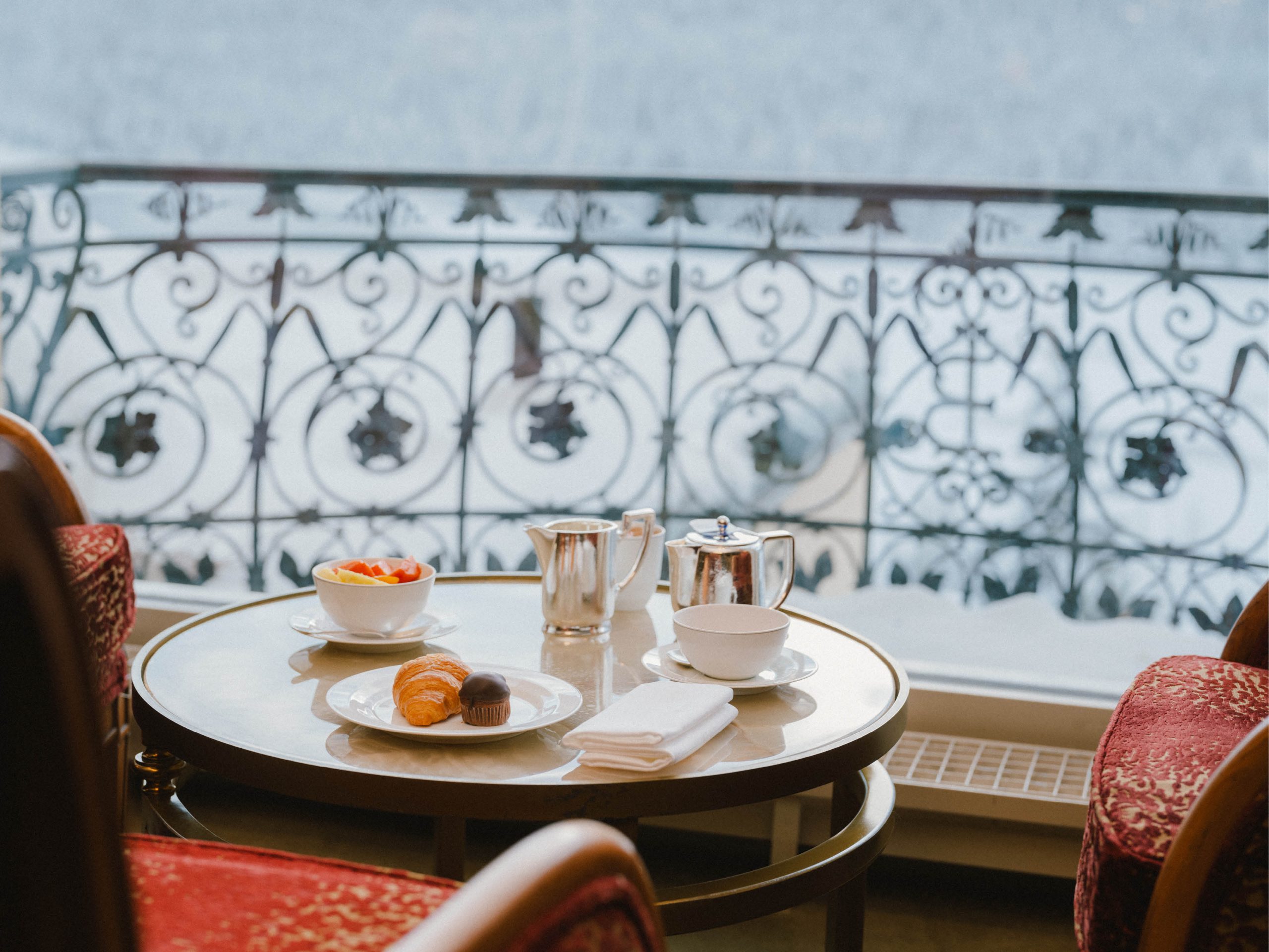 Breakfast table in the lobby lounge beside ornate windows, Kulm Hotel St. Moritz, St. Moritz, Switzerland