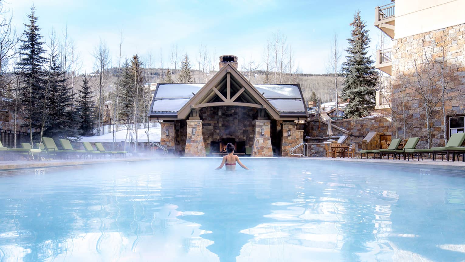 Steam rising from the outdoor heated pool in winter at Four Seasons Resort Vail.