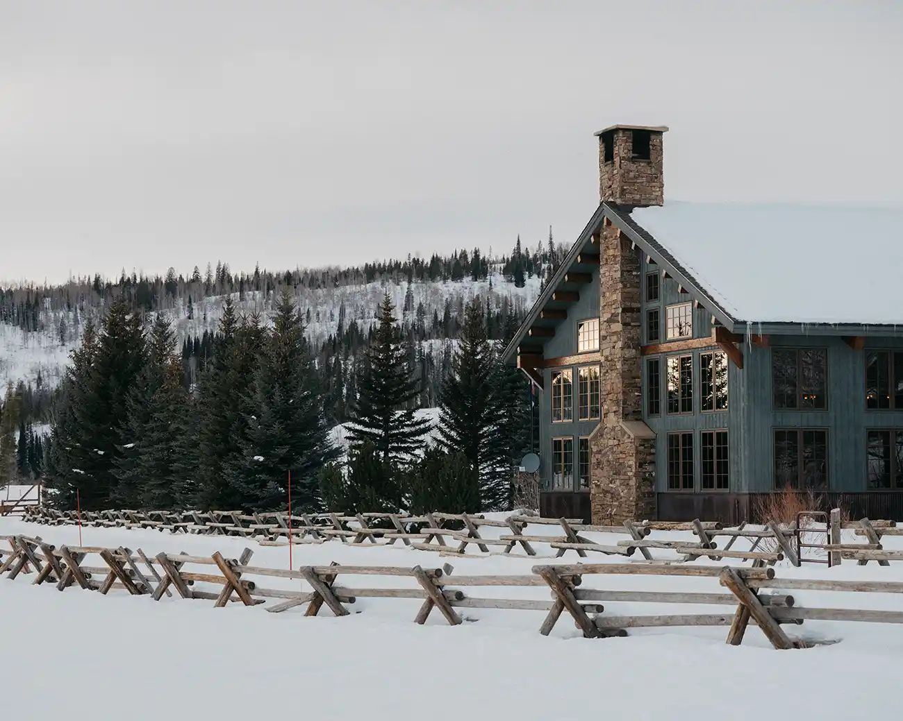 Snow-covered grounds and the timber-and-stone main lodge at Vista Verde Ranch, Clark, Colorado.