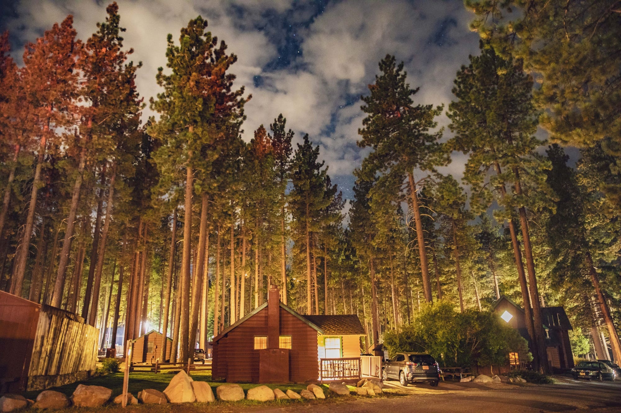 Cabin among tall pine trees beneath a starry night sky at Zephyr Cove Resort, Zephyr Cove, USA