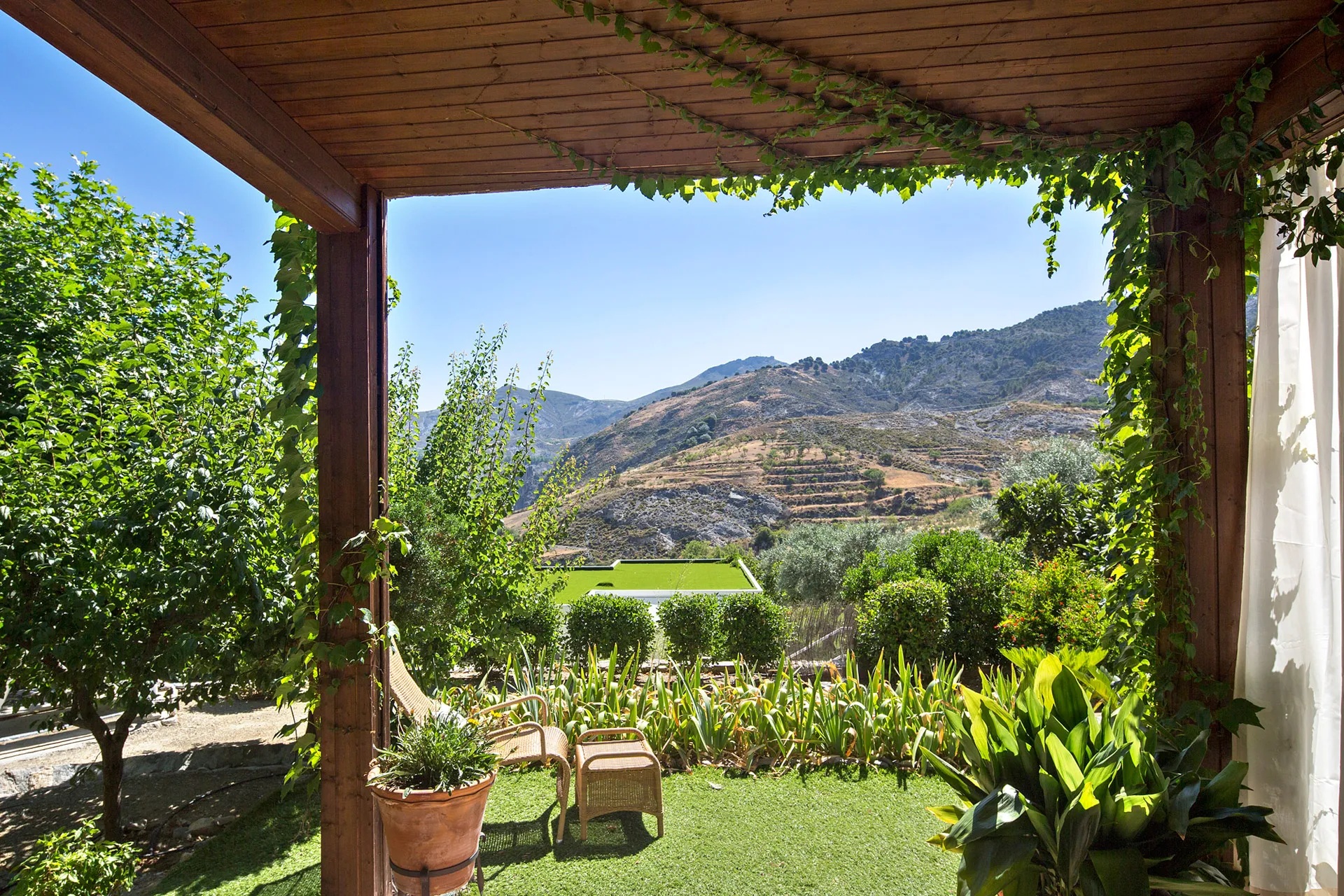 Shaded terrace looking over the surrounding mountain landscape at La Almunia del Valle, Monachil, Spain