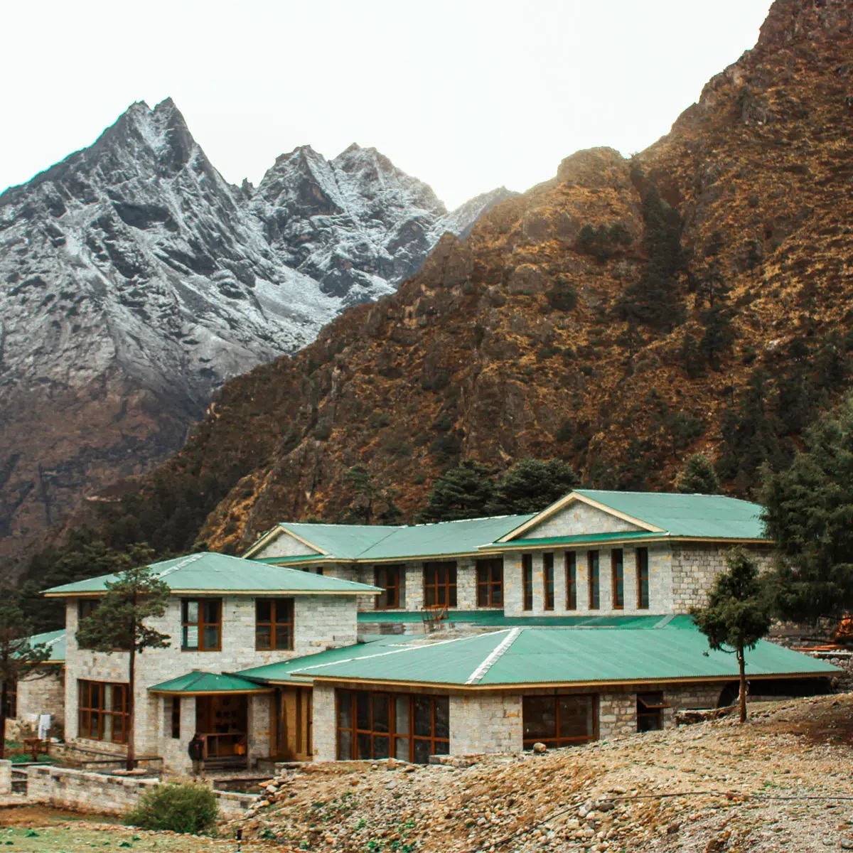 Green-roofed mountain lodge beneath rugged peaks at Yeti Mountain Home, Everest Region (Khumbu), Nepal