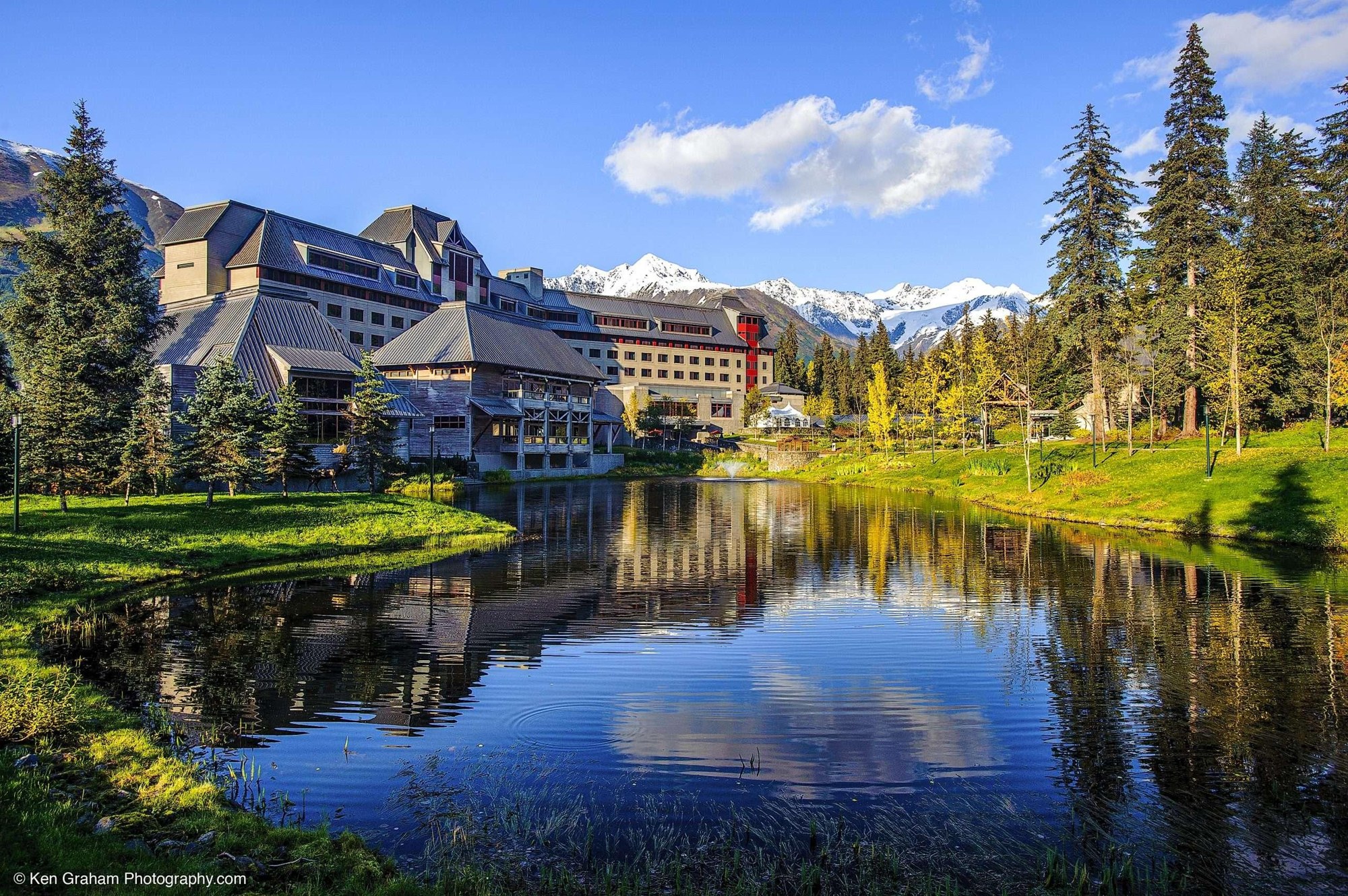 Château-style resort hotel reflected in a pond at the foot of the mountains, Alyeska Resort, Alaska, USA