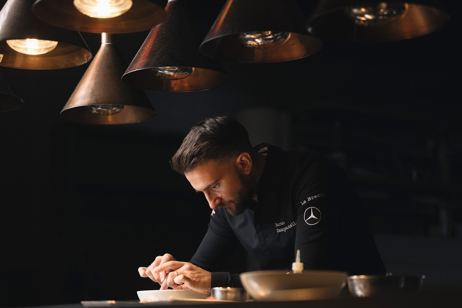 Chef Marco Campanella plating a dish at Tschuggen Grand Hotel, Arosa, Switzerland