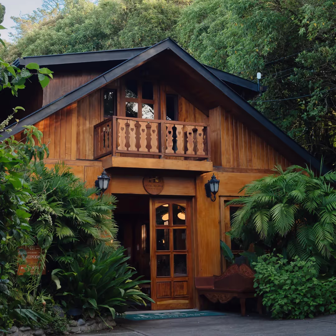 Wooden chalet exterior framed by lush mountain greenery, Hotel Belmar, Monteverde, Costa Rica